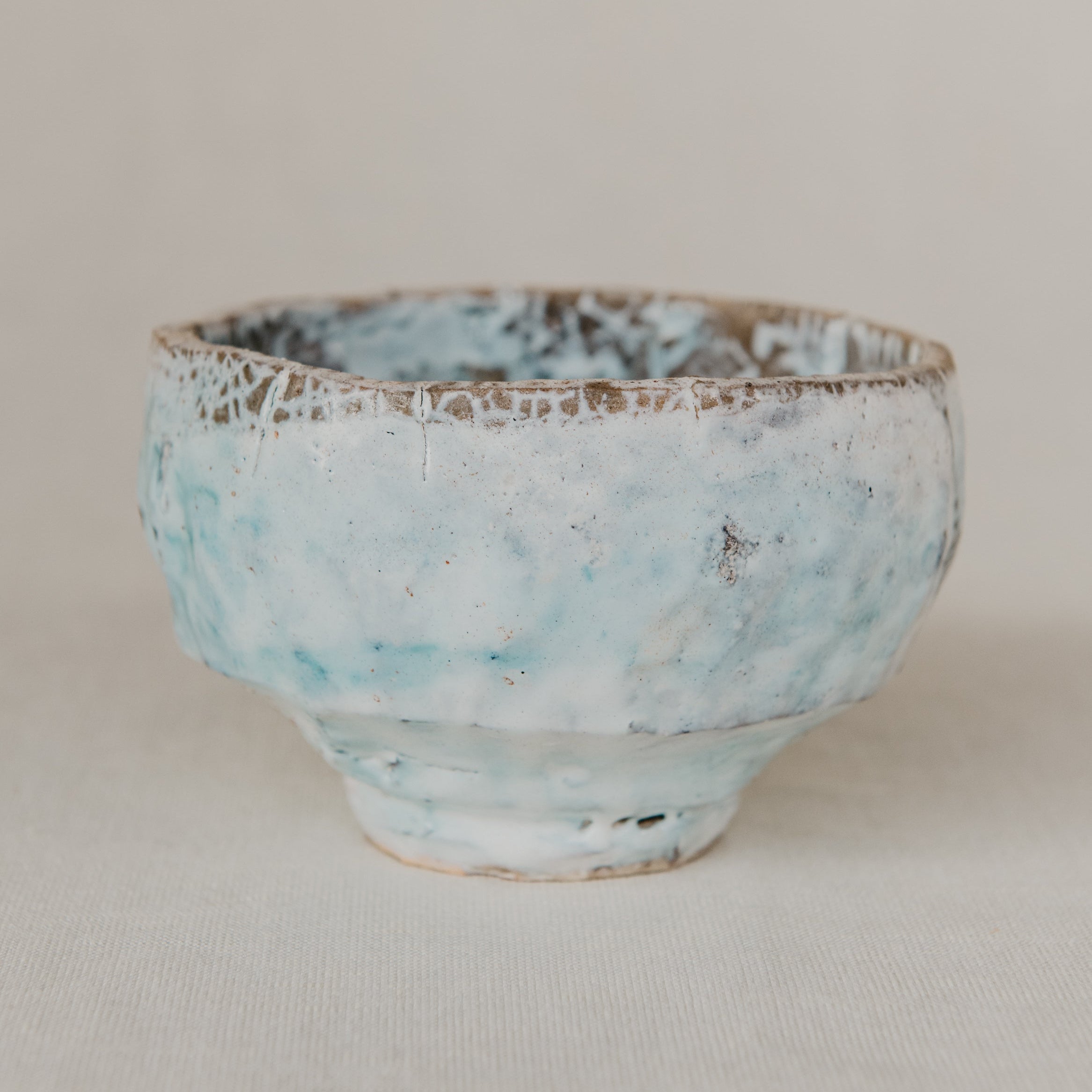 Small ceramic bowl with a textured surface on a plain background