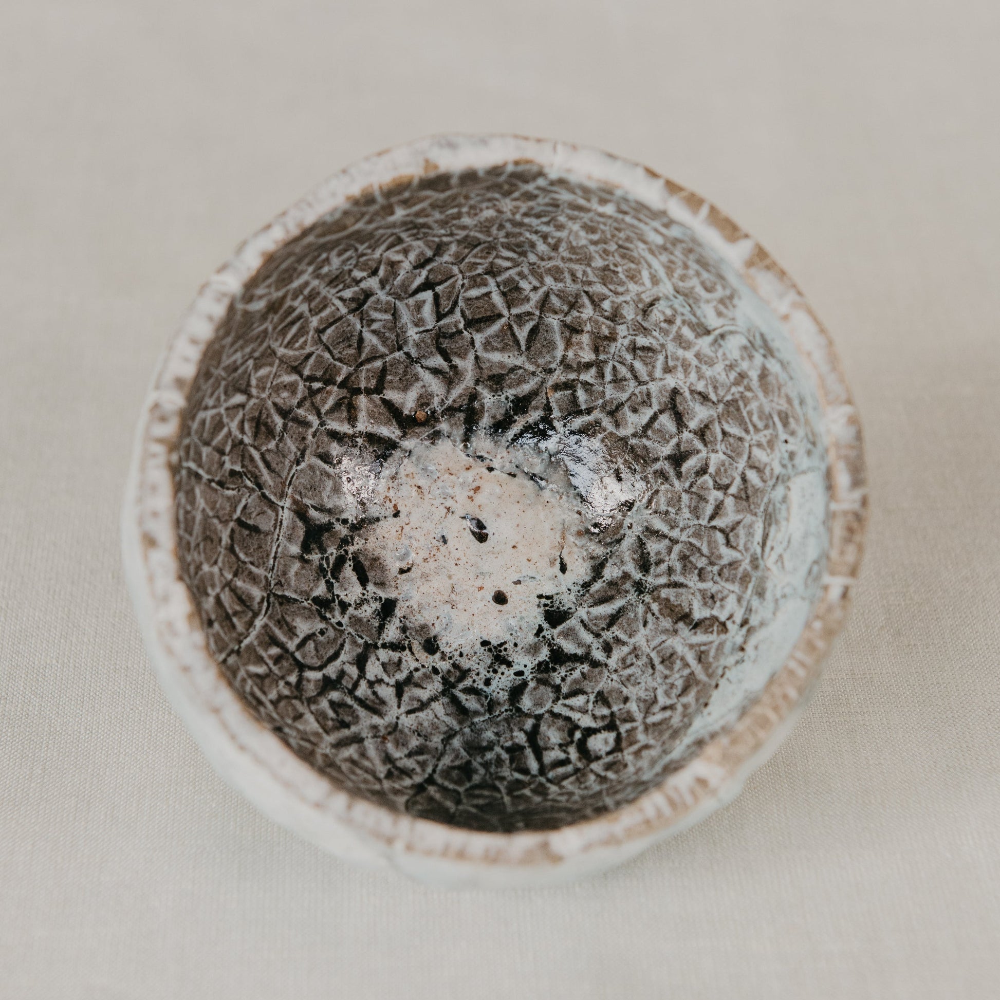 Textured ceramic bowl on a neutral background