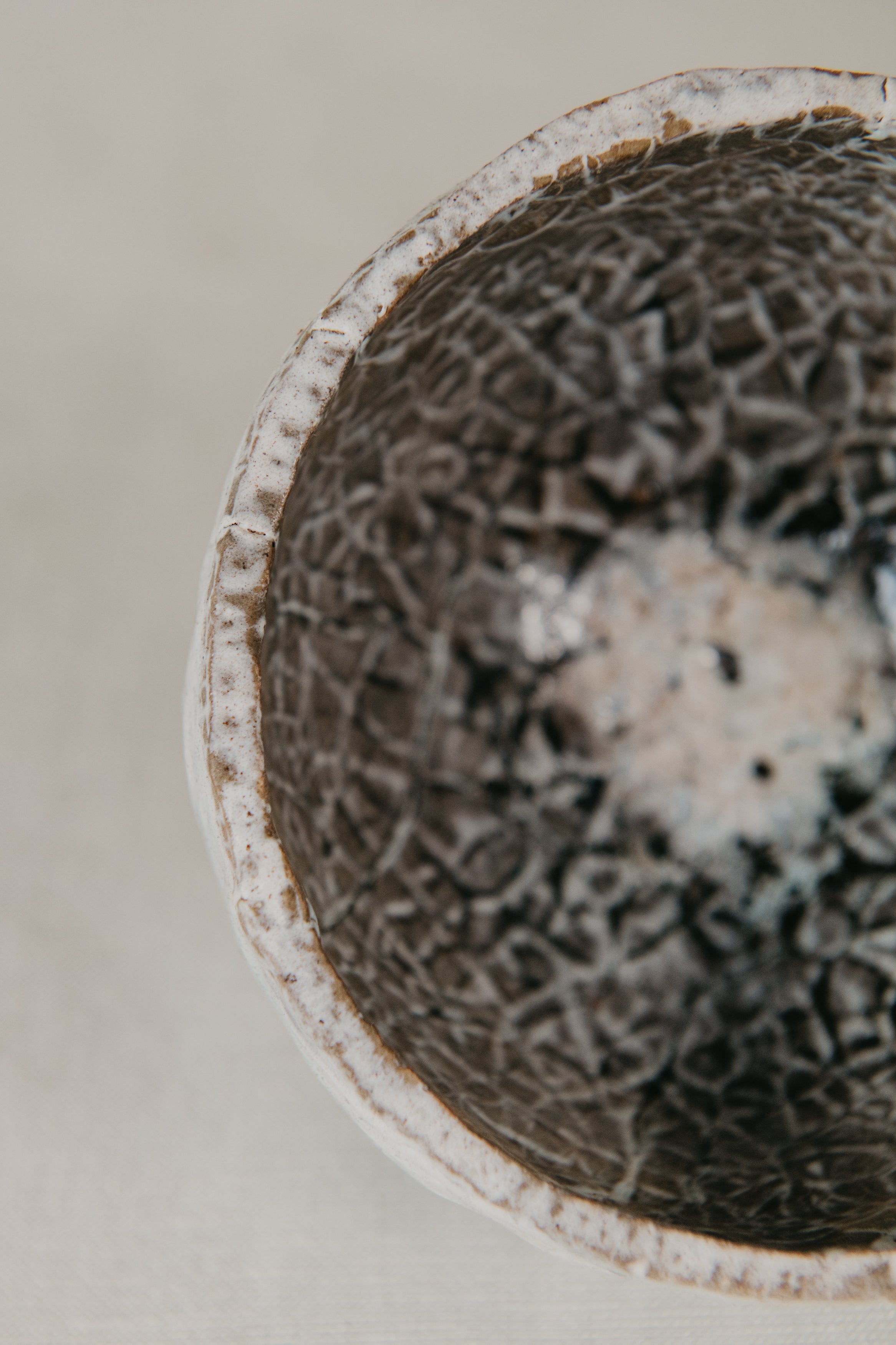Close-up of a textured ceramic bowl on a neutral background