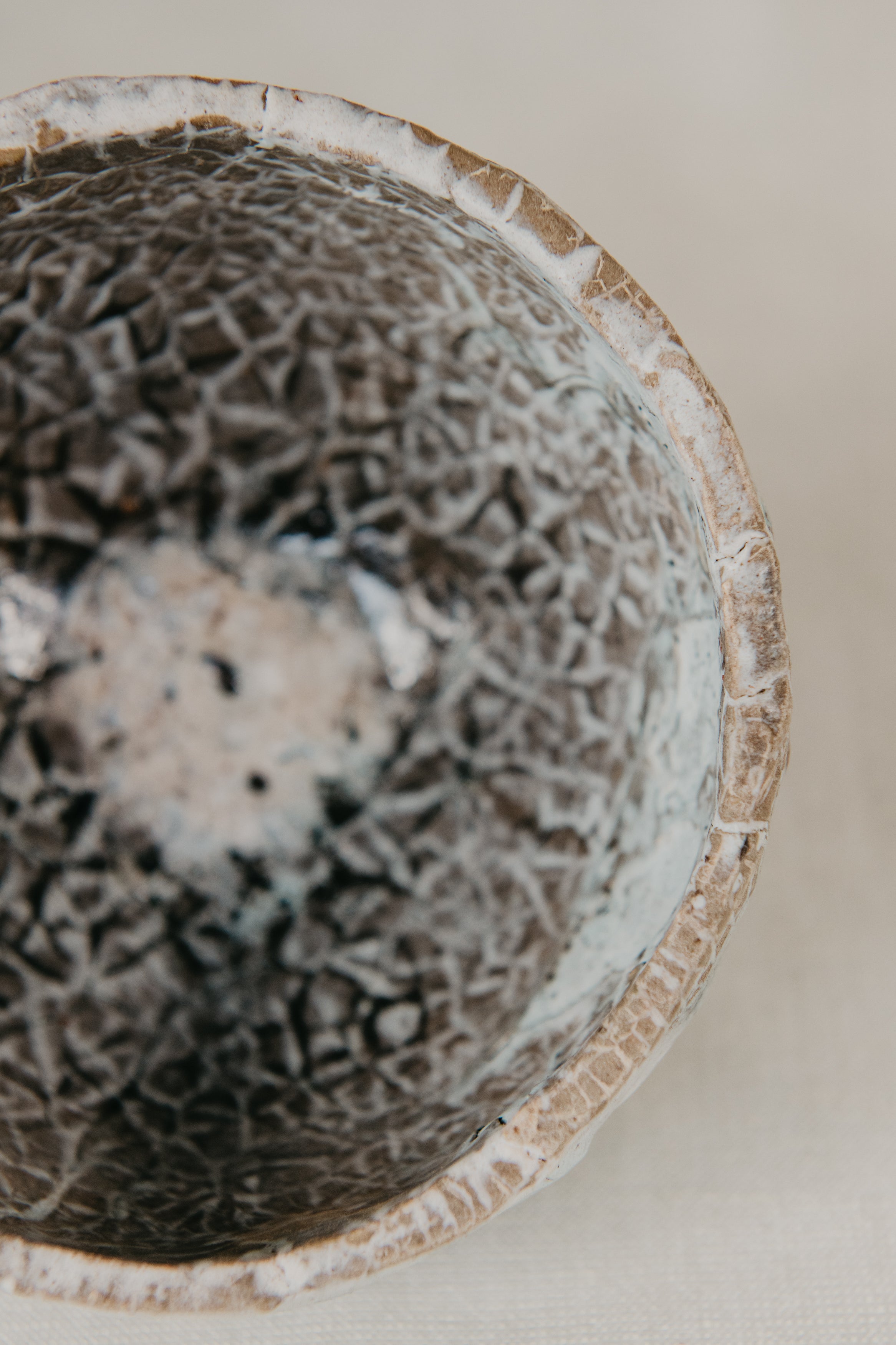 Close-up of a textured ceramic bowl with a neutral background