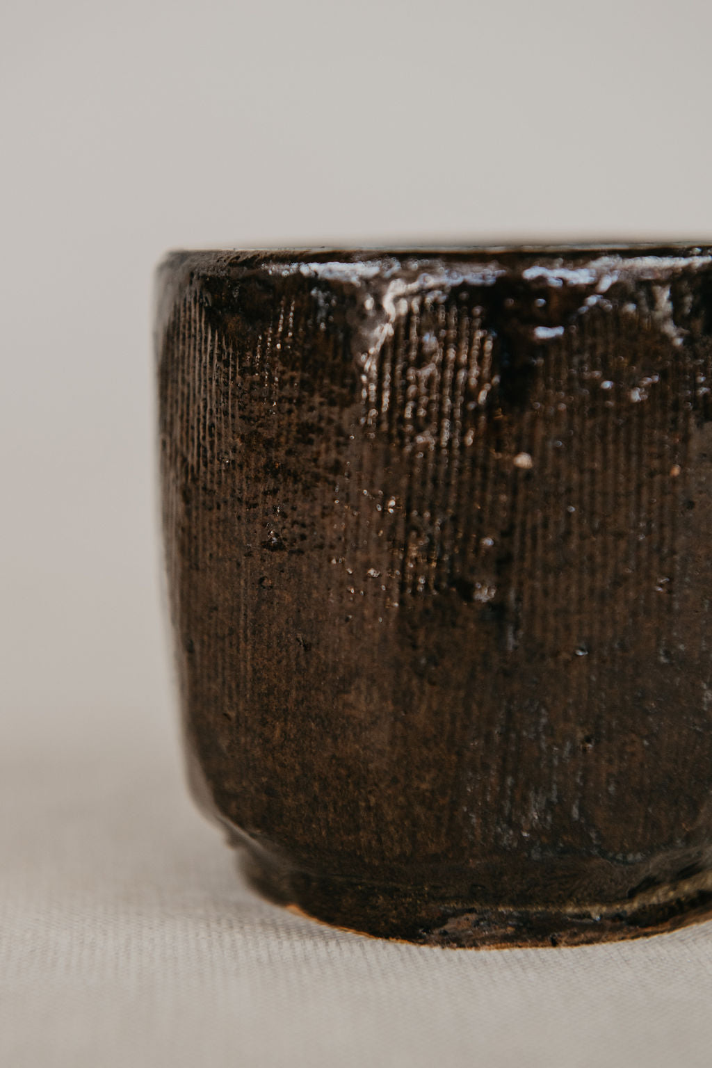 Close-up of a dark brown ceramic cup on a light gray background