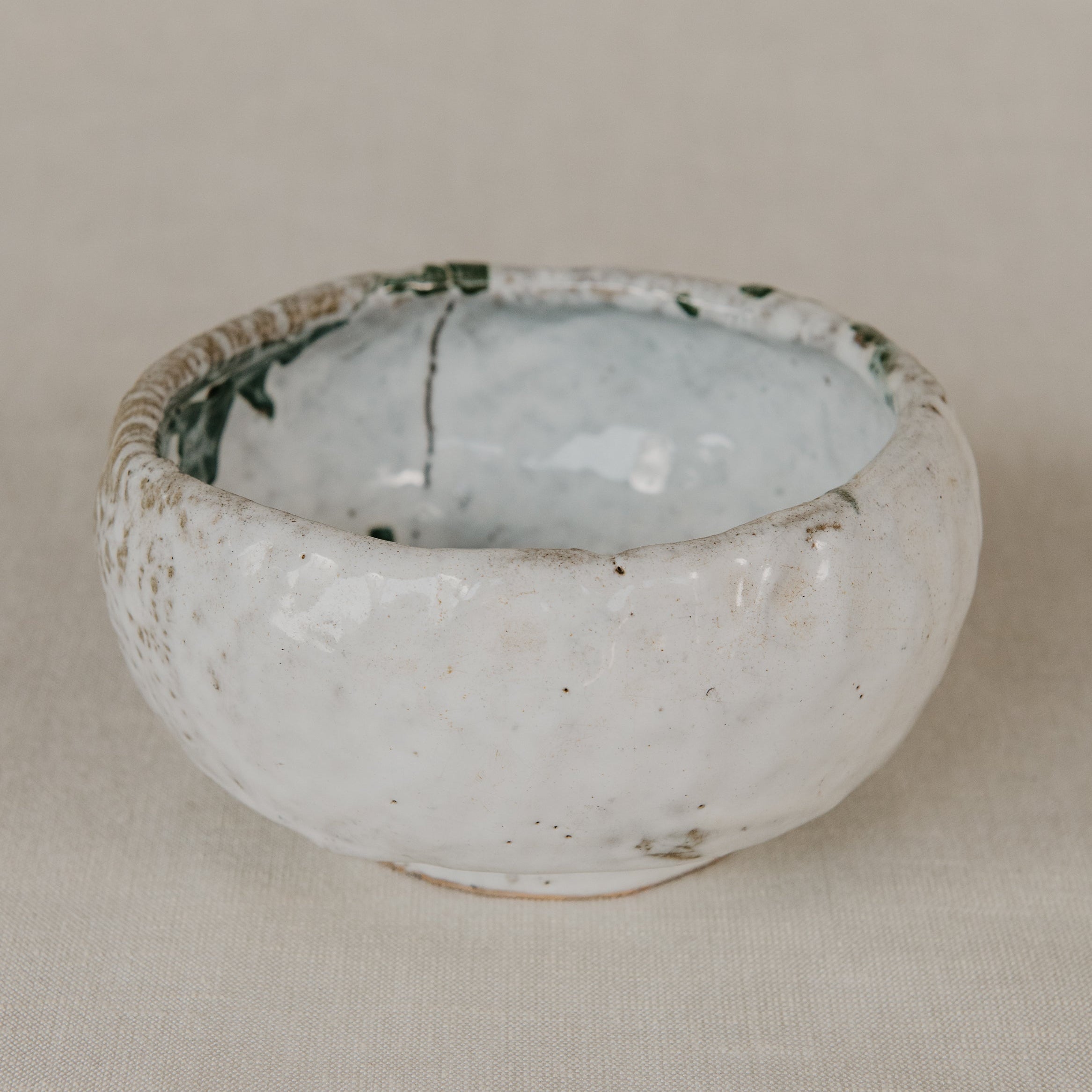 Small ceramic bowl with a textured surface on a beige background