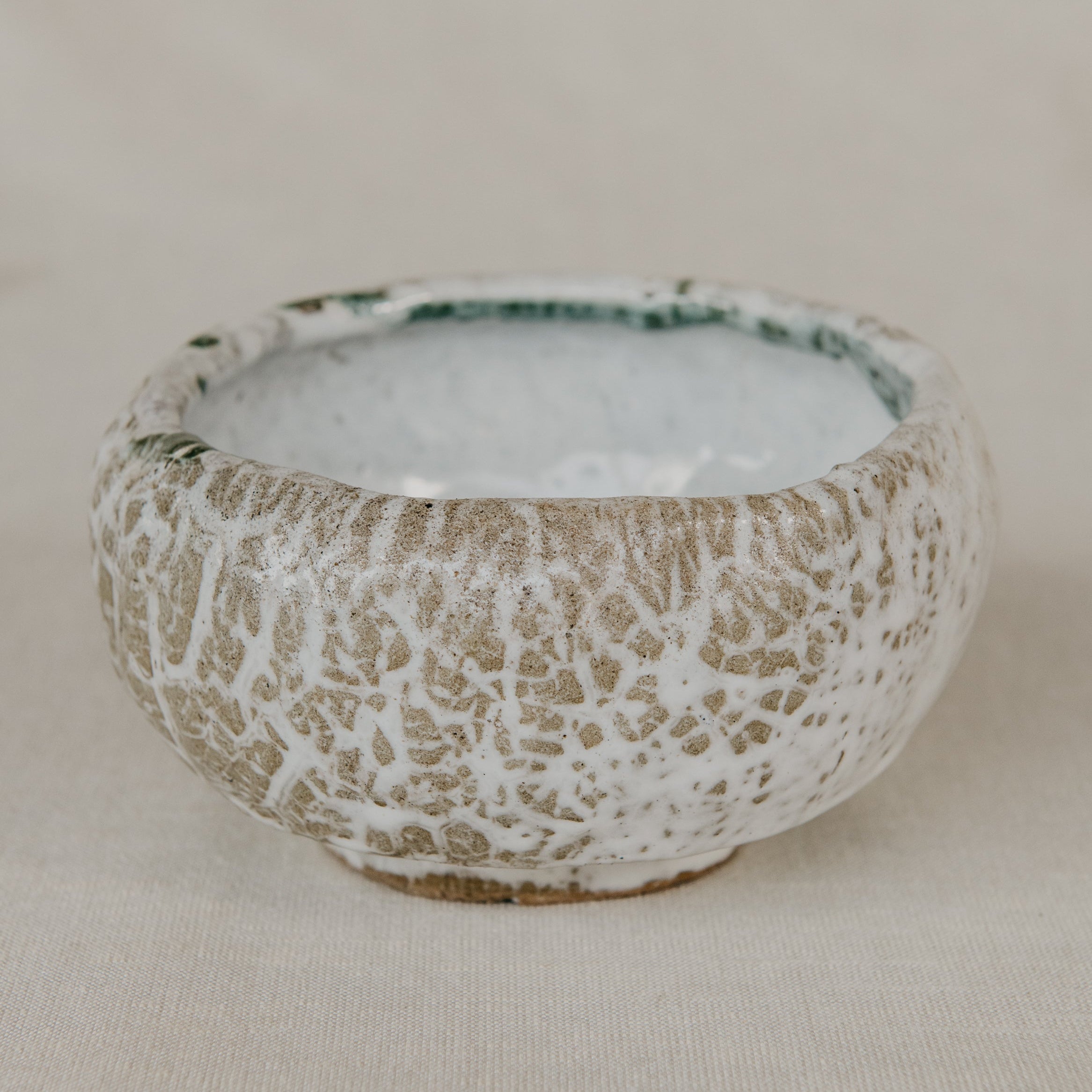 Small ceramic bowl with textured surface on a plain background
