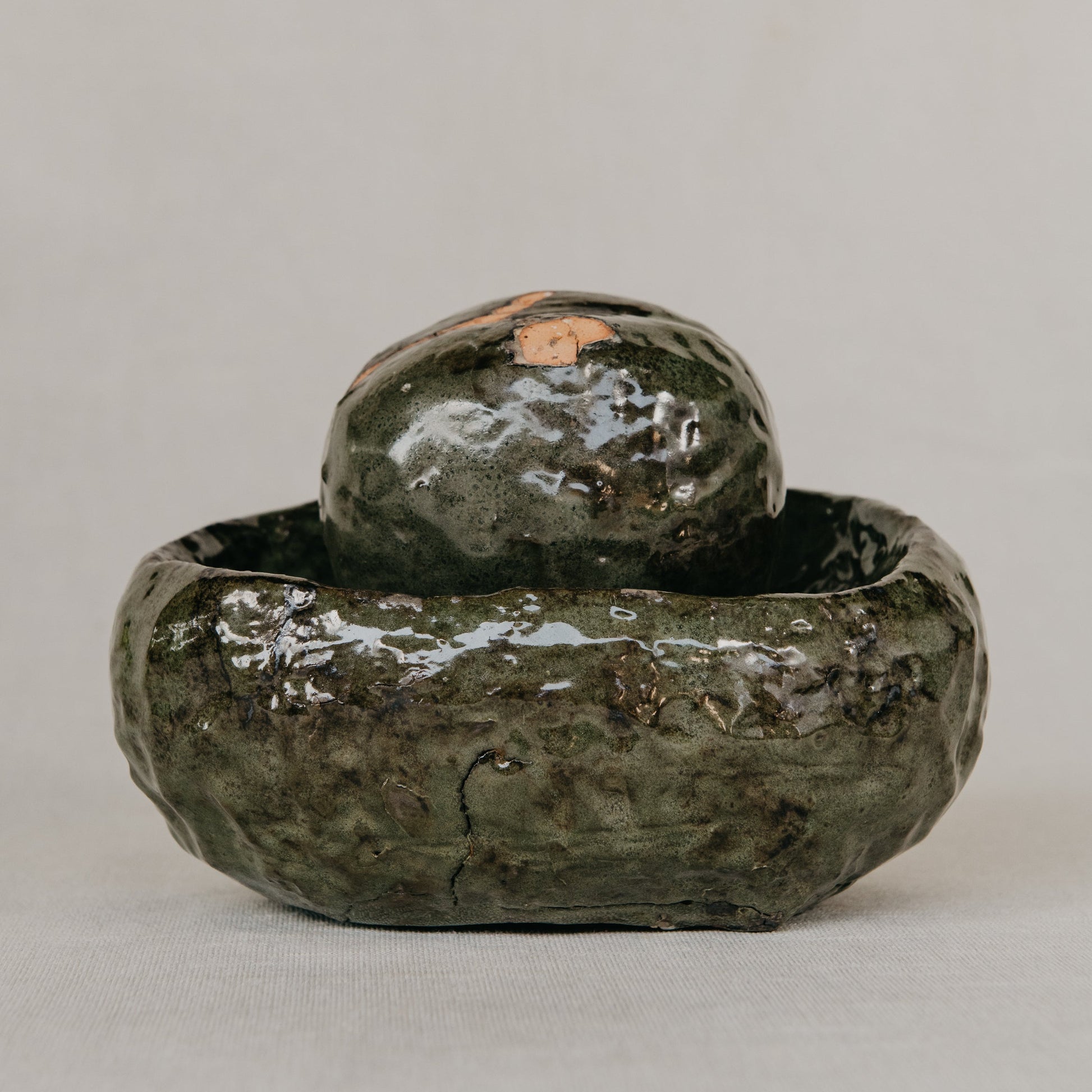 Green ceramic object on a gray background