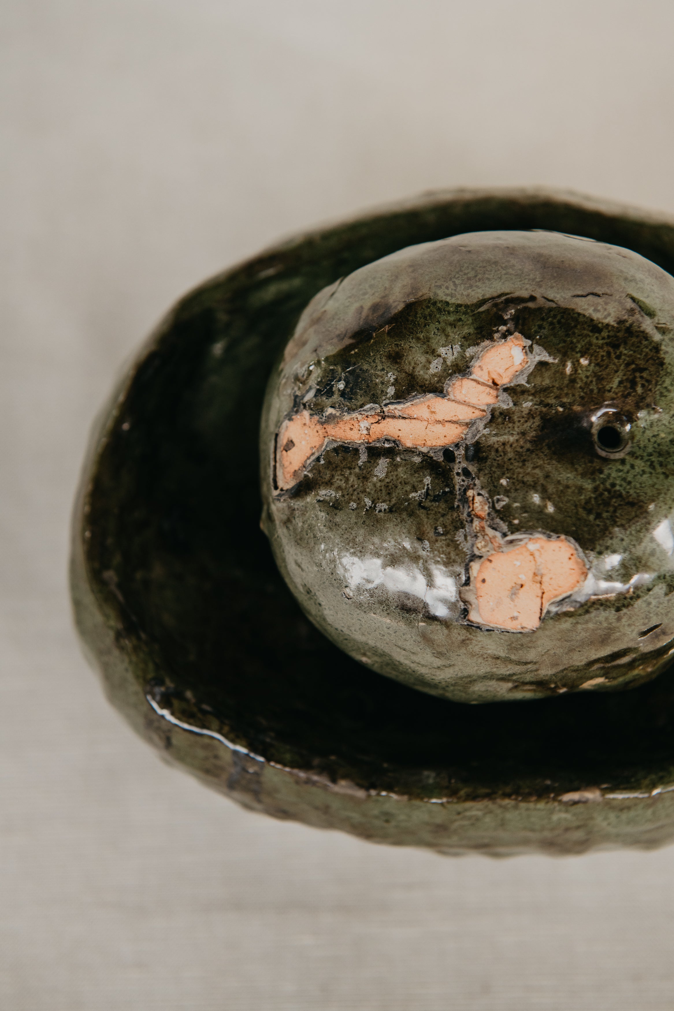 Close-up of a textured stone with a natural, earthy appearance on a neutral background