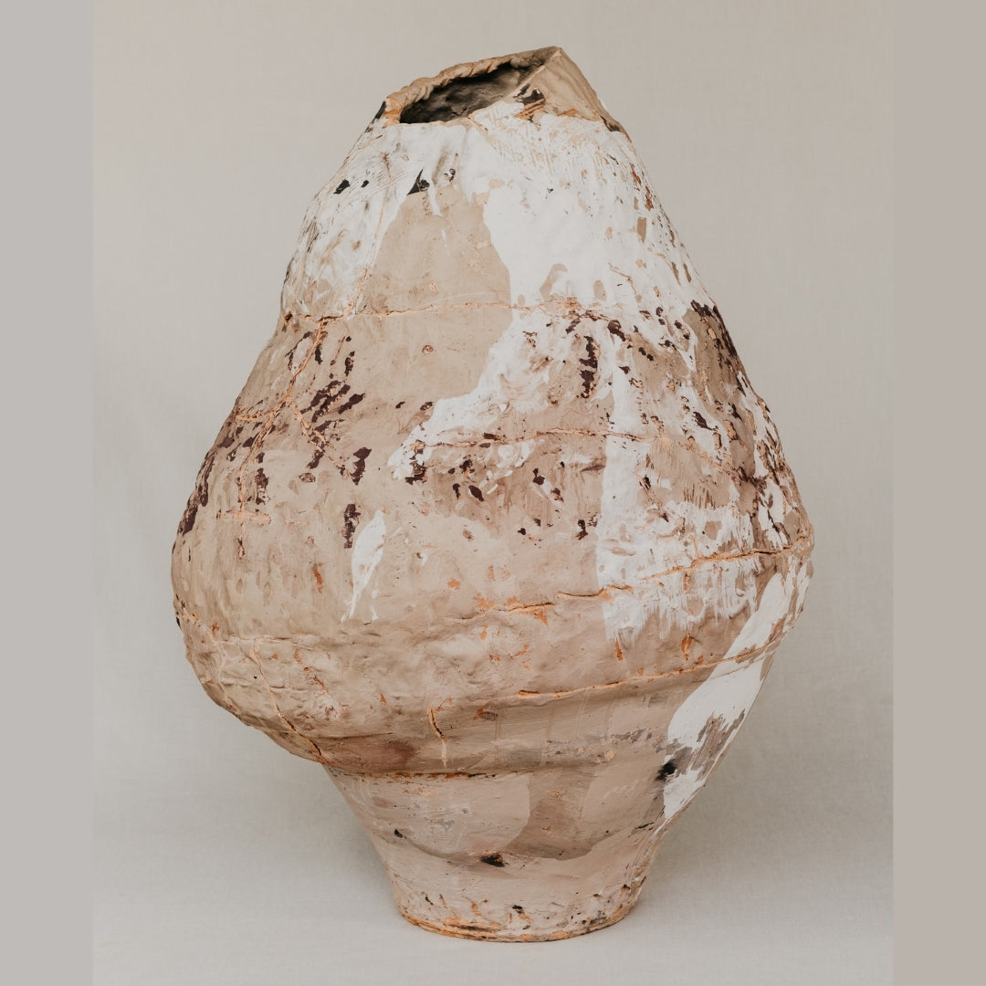 Vintage ceramic vase with a textured surface on a plain background