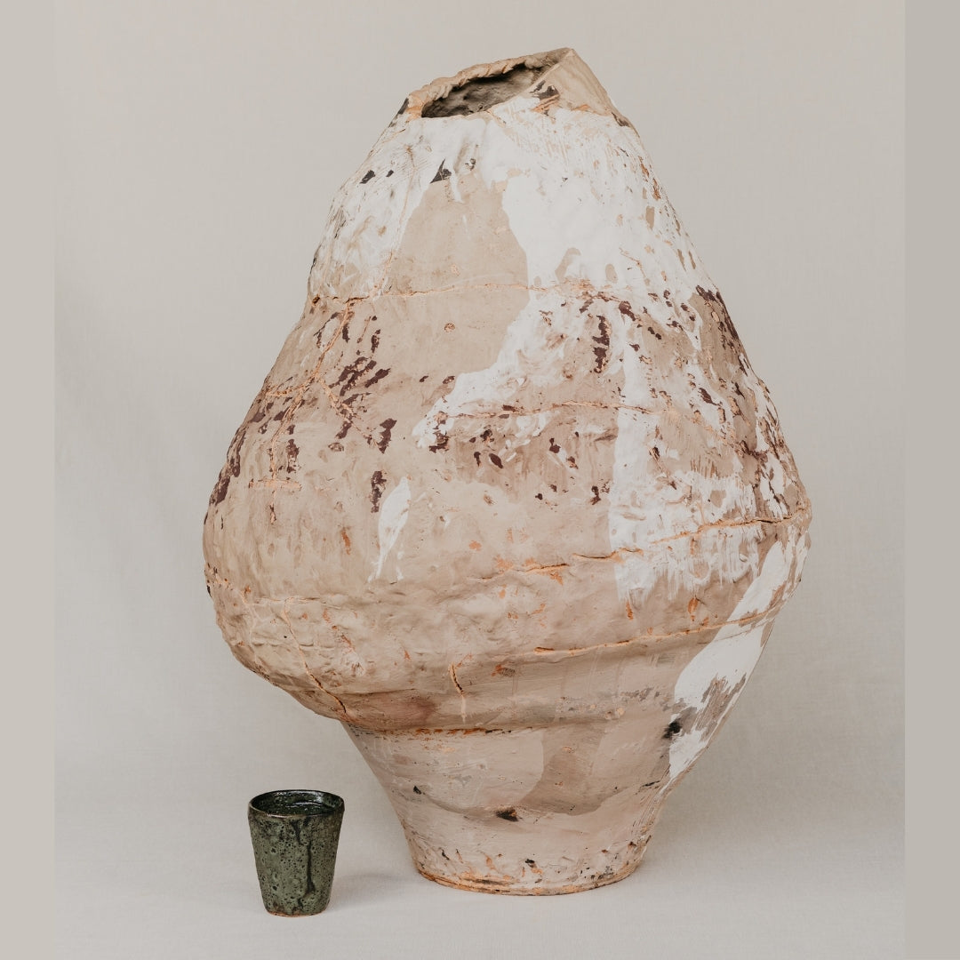 Large textured ceramic vase on a plain background