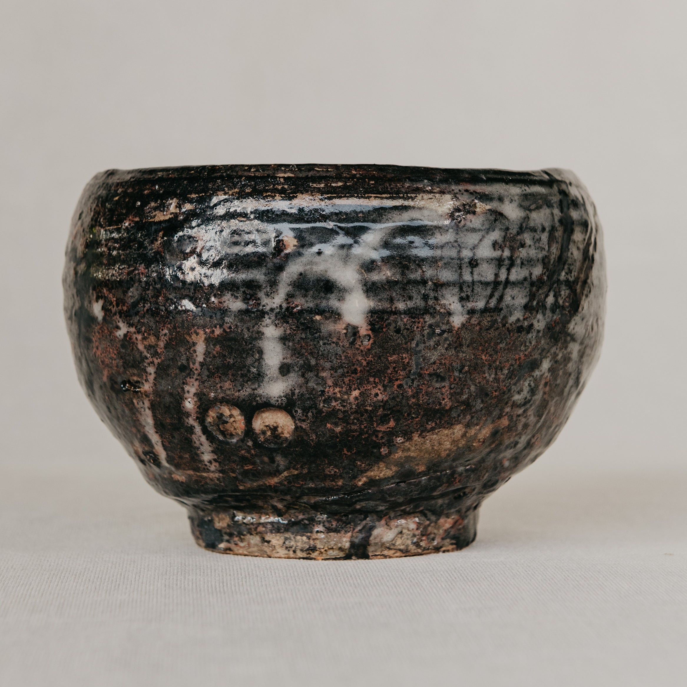 Black ceramic bowl with textured surface on a light gray background