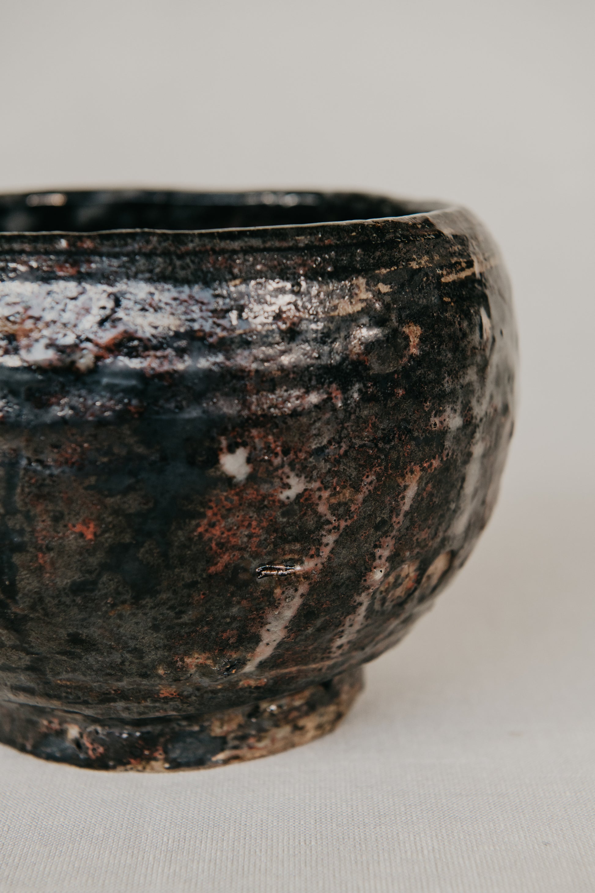 Black ceramic bowl with textured surface on a light gray background