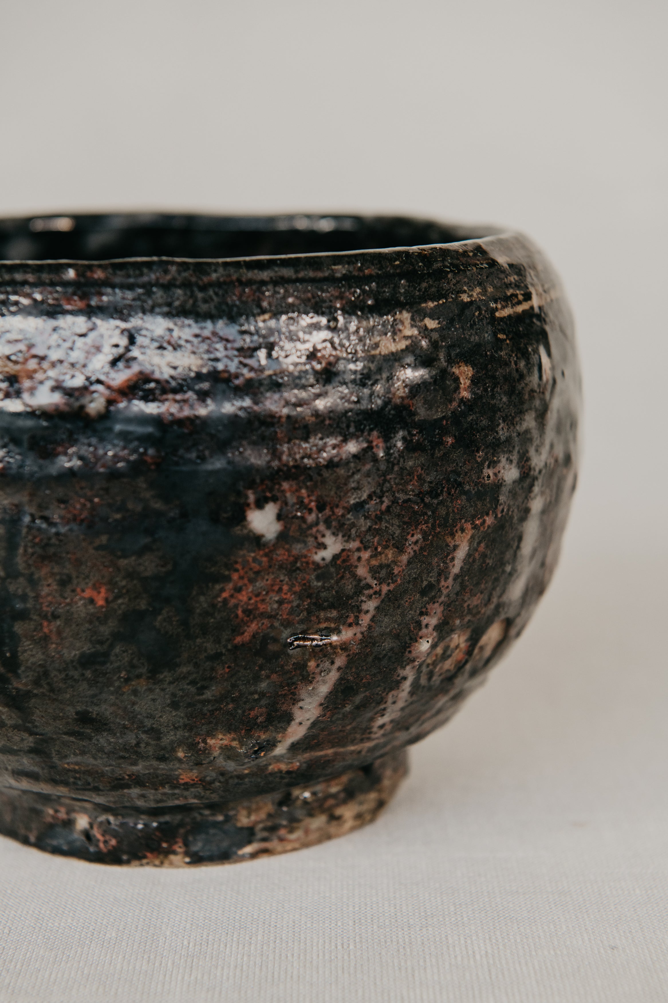 Black ceramic bowl with textured surface on a light gray background