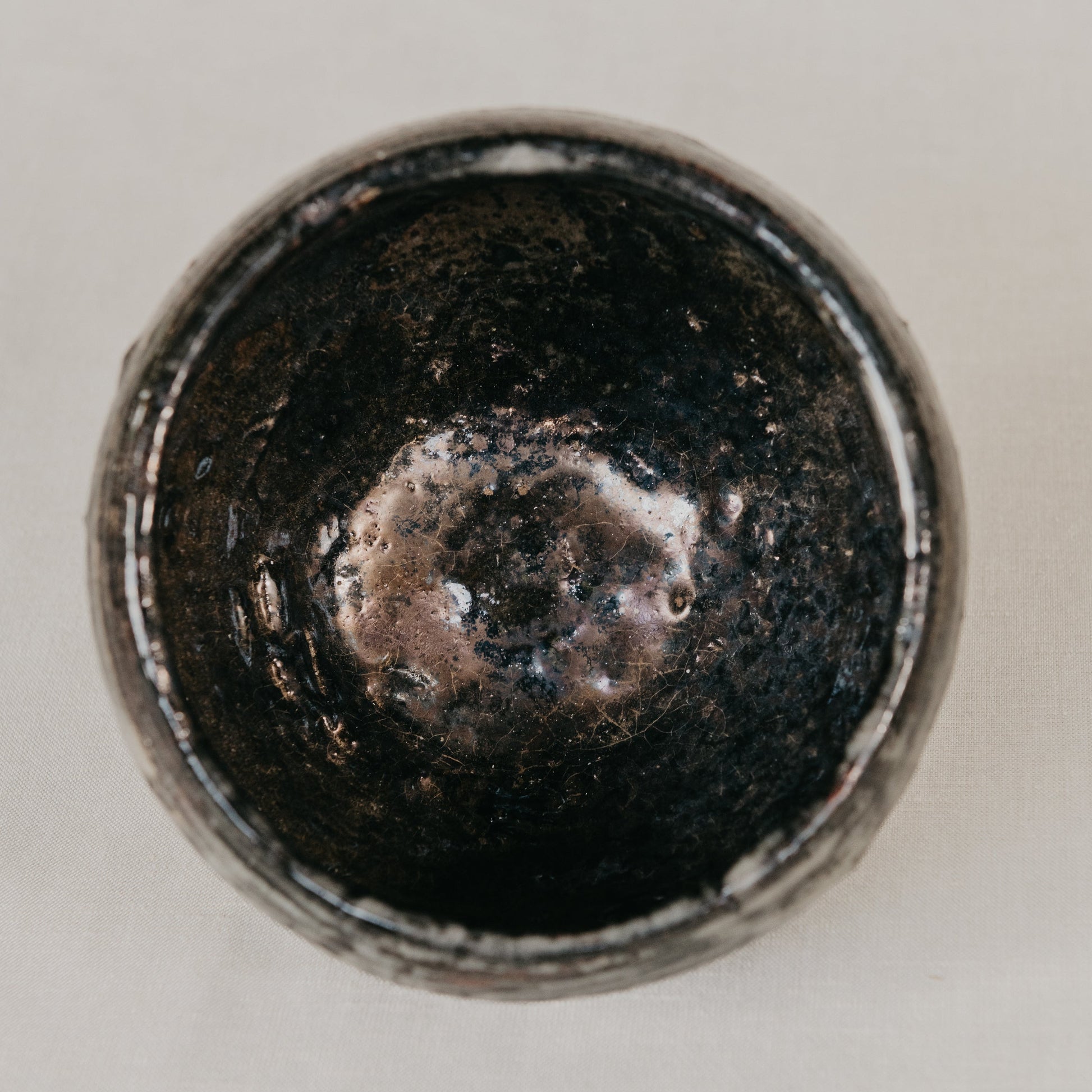 Close-up of a metallic object with a textured surface on a light gray background