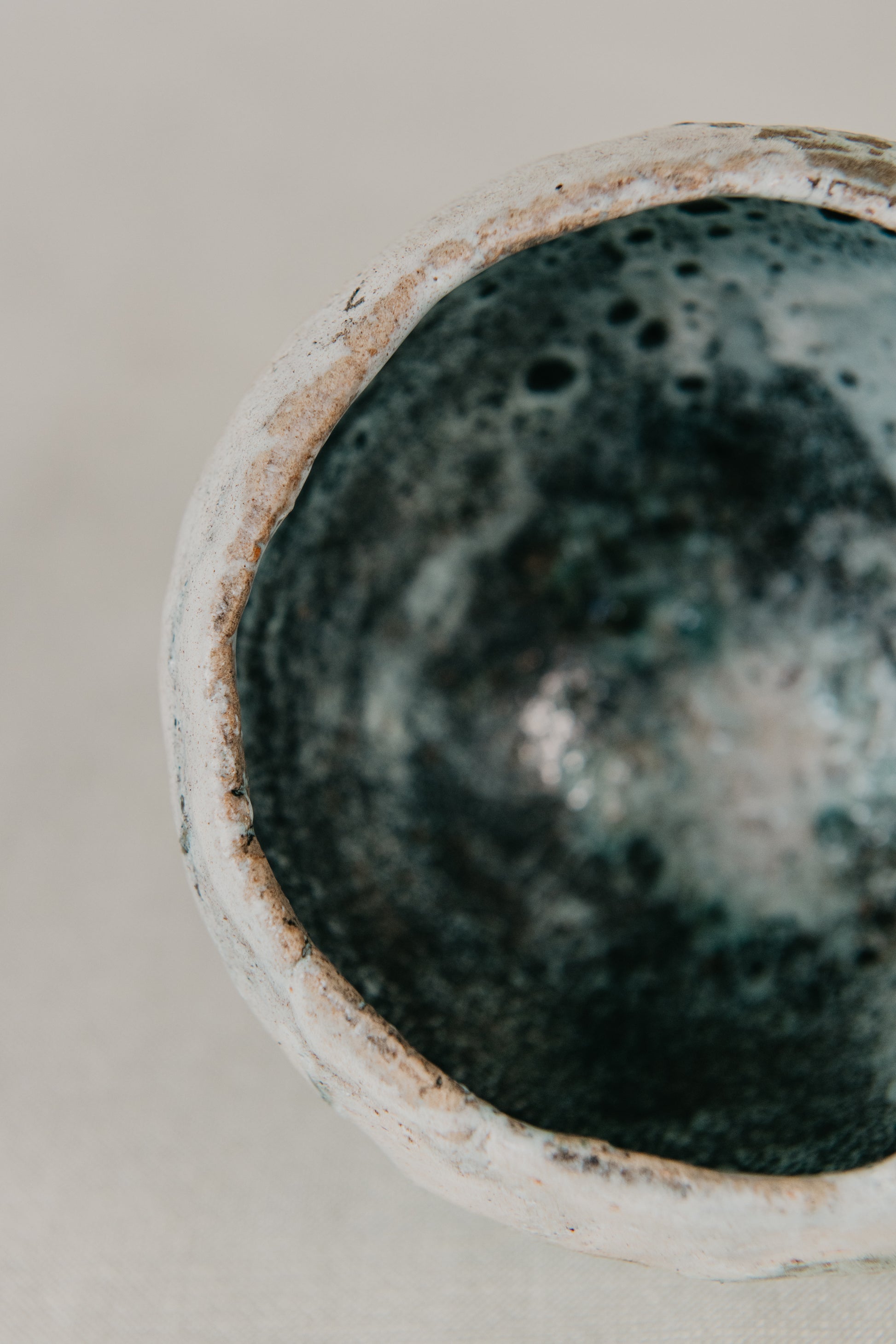 Close-up of a ceramic pot with textured surface on a neutral background
