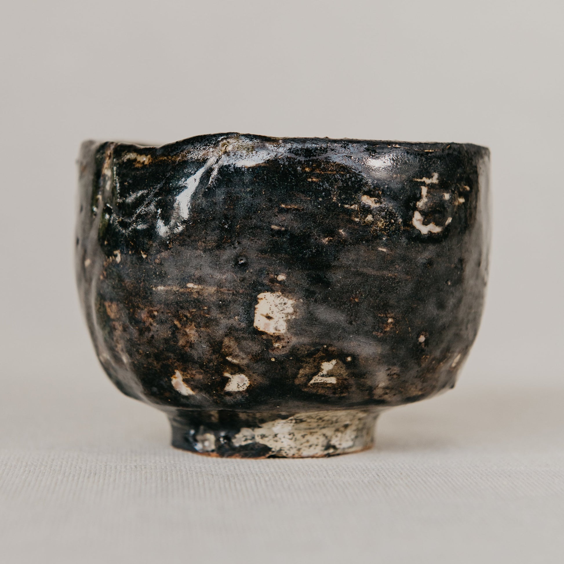 Black ceramic bowl with a textured surface on a gray background
