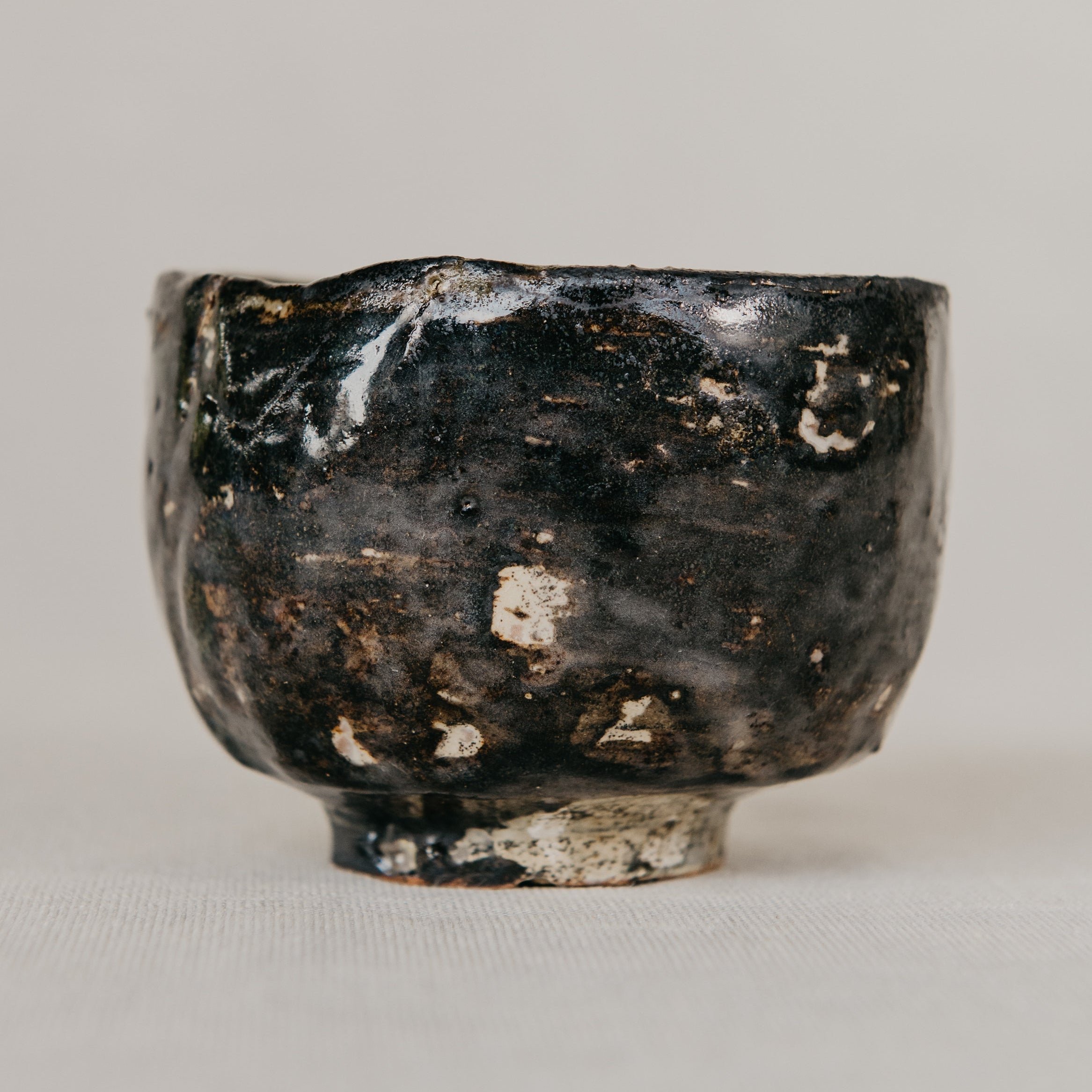 Black ceramic bowl with a textured surface on a gray background