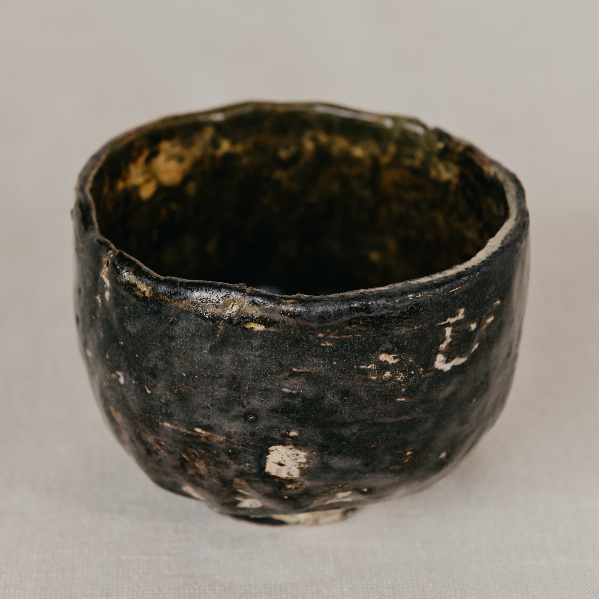 Black ceramic cup with a textured surface on a light gray background