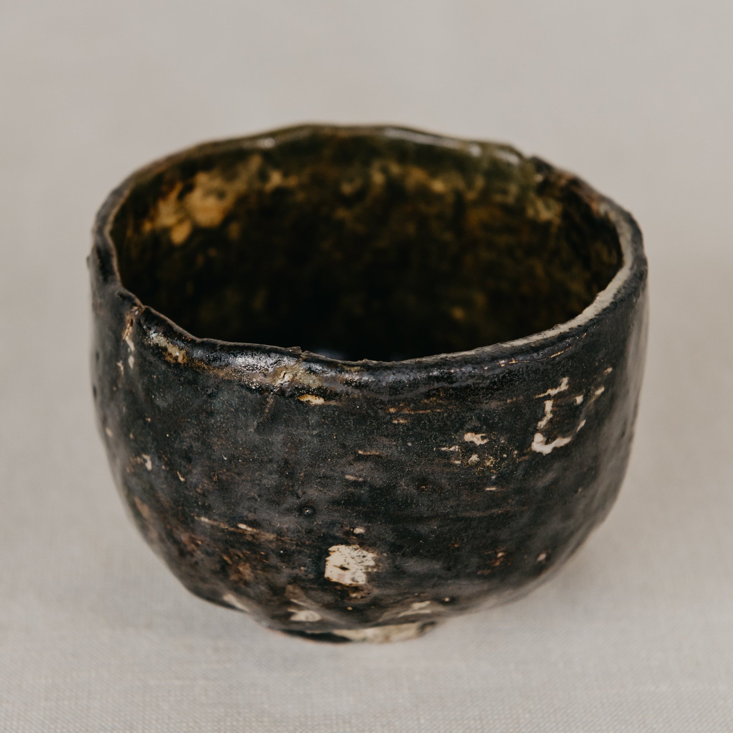 Black ceramic cup with a textured surface on a light gray background