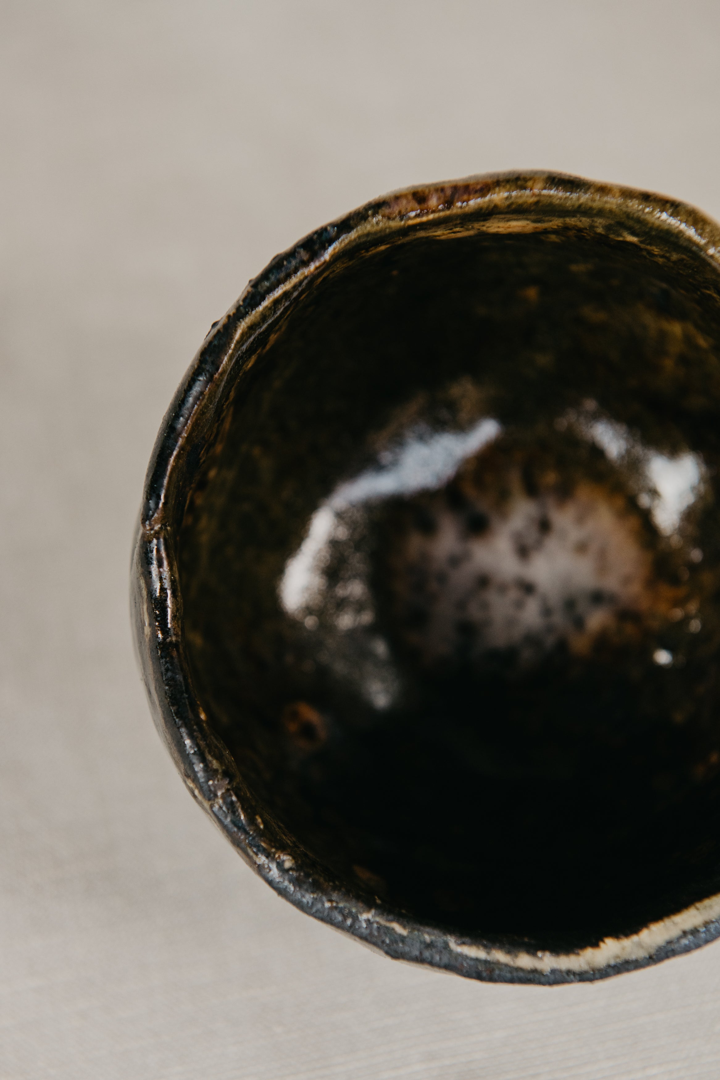 Close-up of a dark ceramic bowl on a neutral background