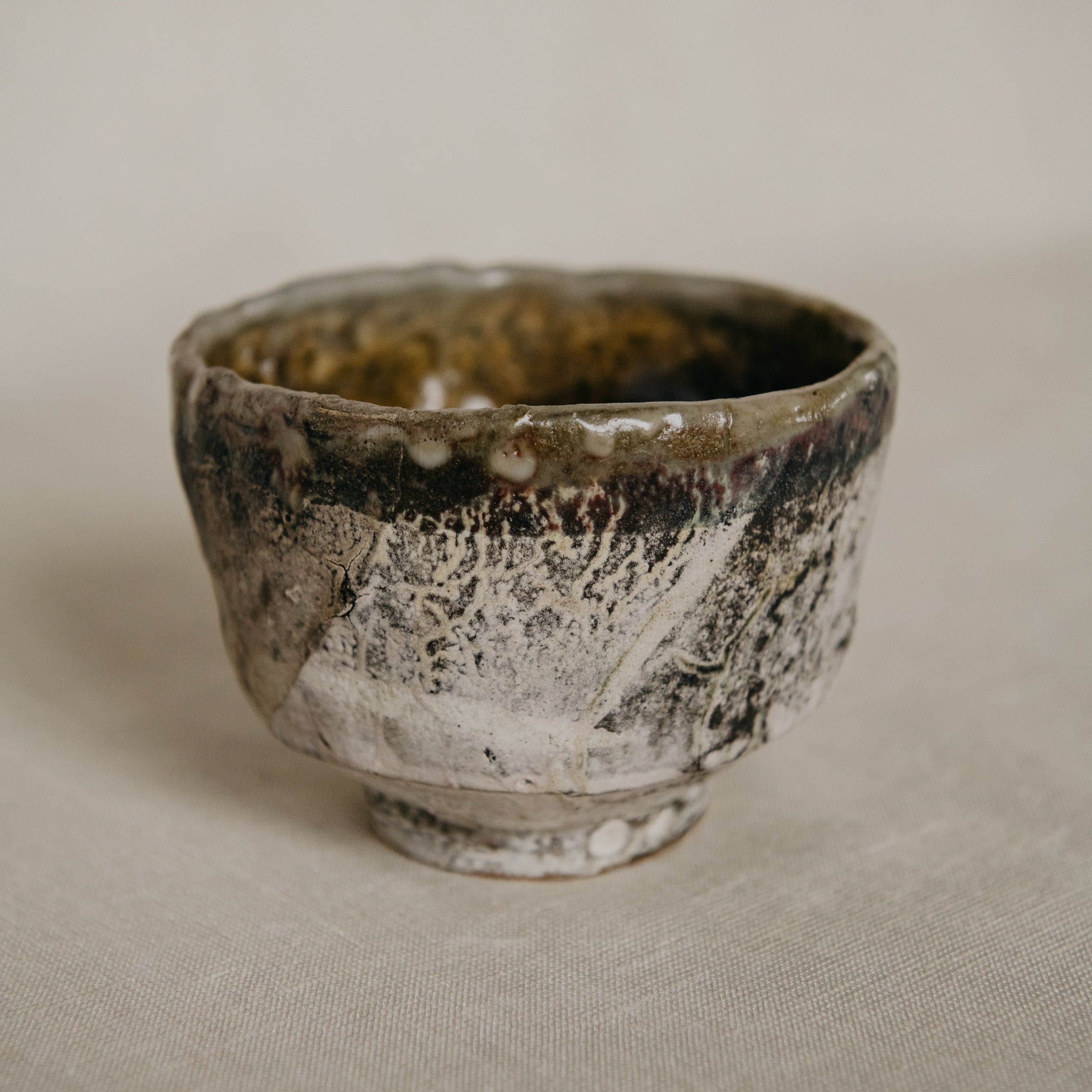 Vintage ceramic cup with a textured surface on a beige background