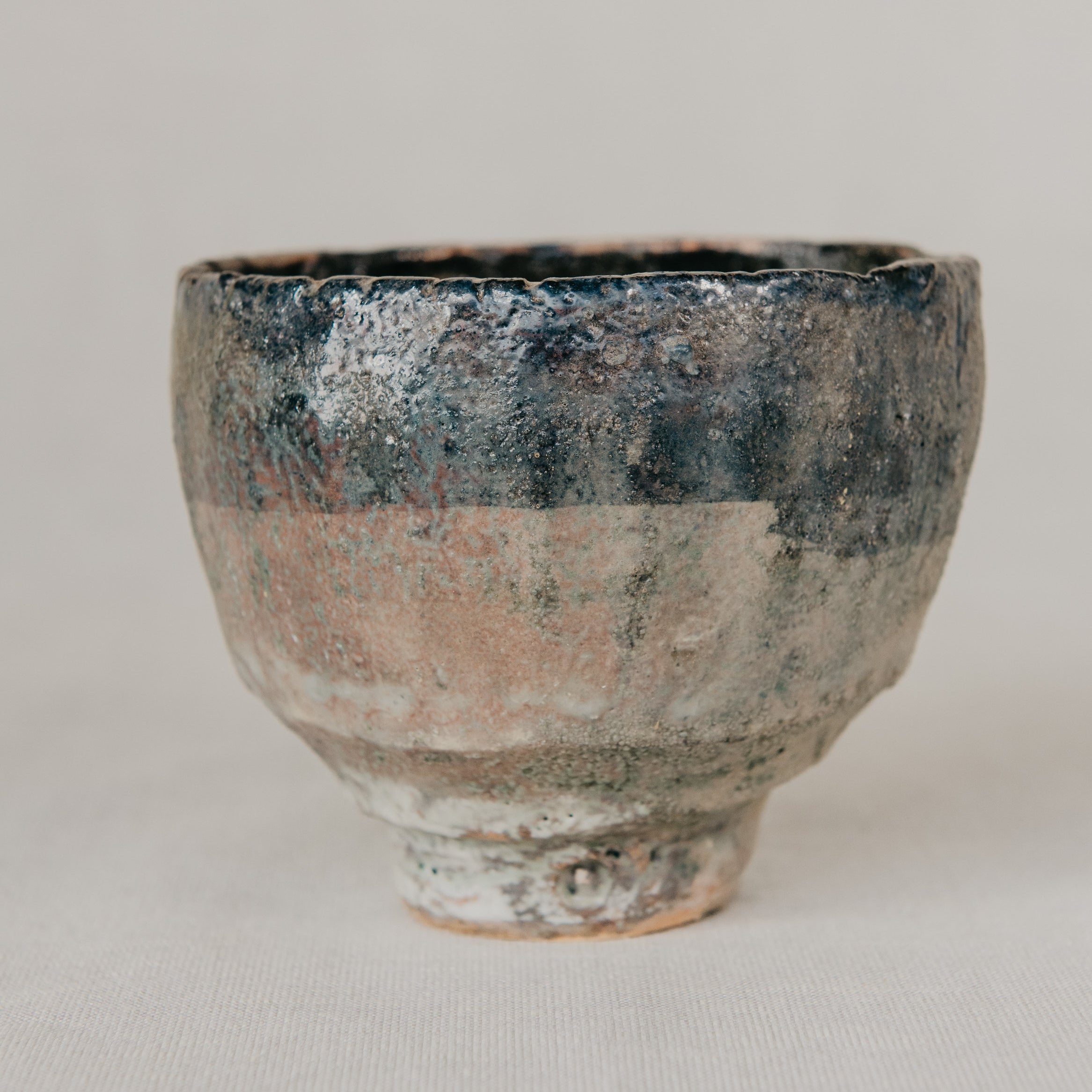 Ceramic cup with a textured surface on a plain background