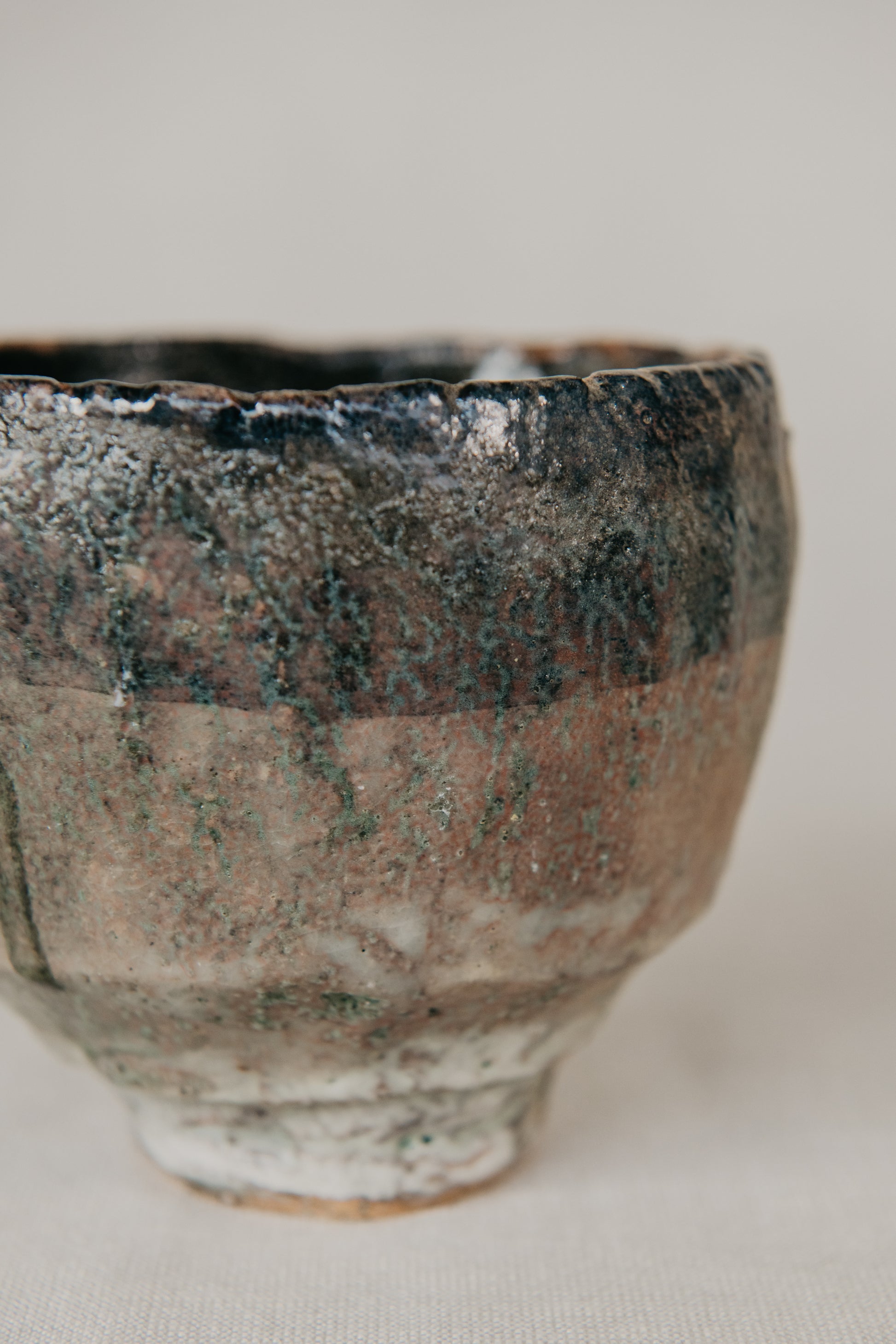 Ceramic cup with textured surface on a neutral background