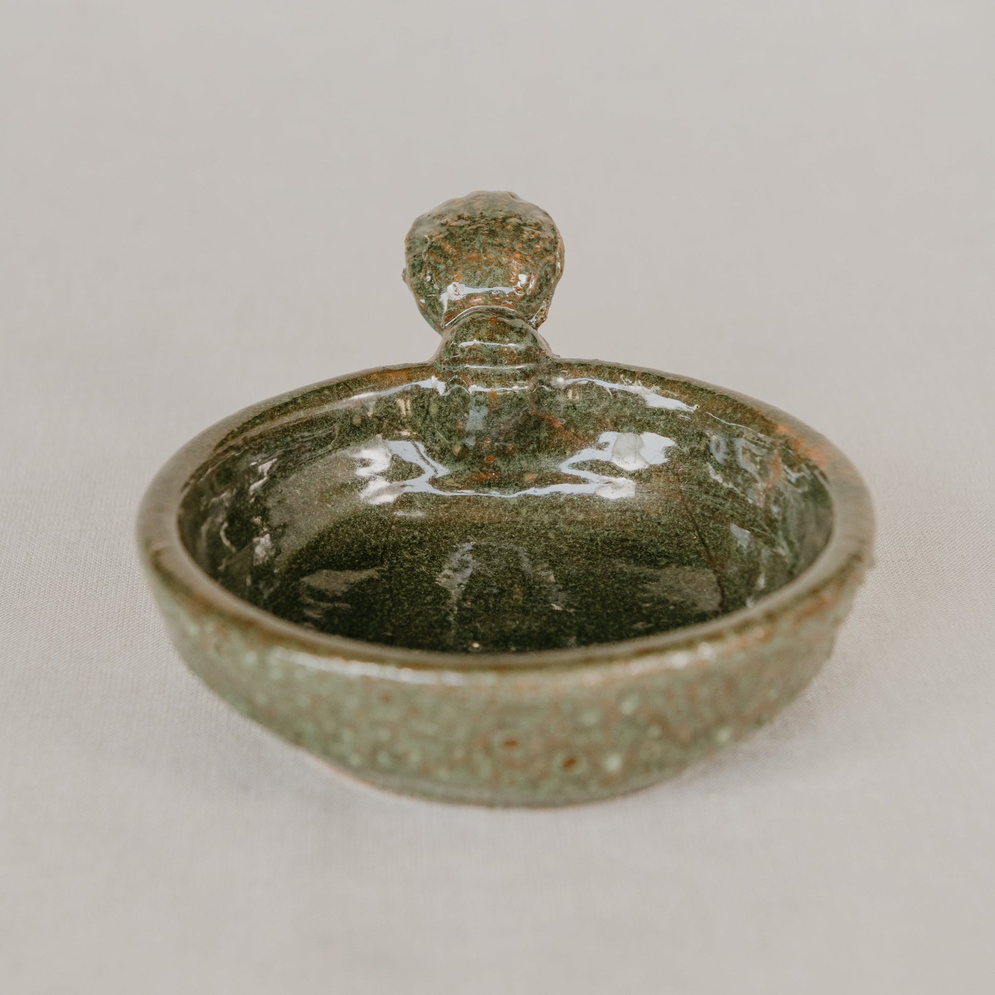 Green ceramic dish with lid on a white background