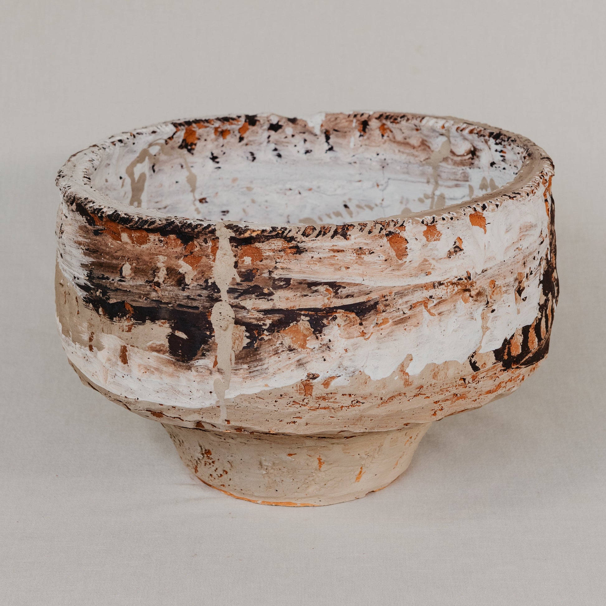 Ceramic bowl with rustic texture on a plain background