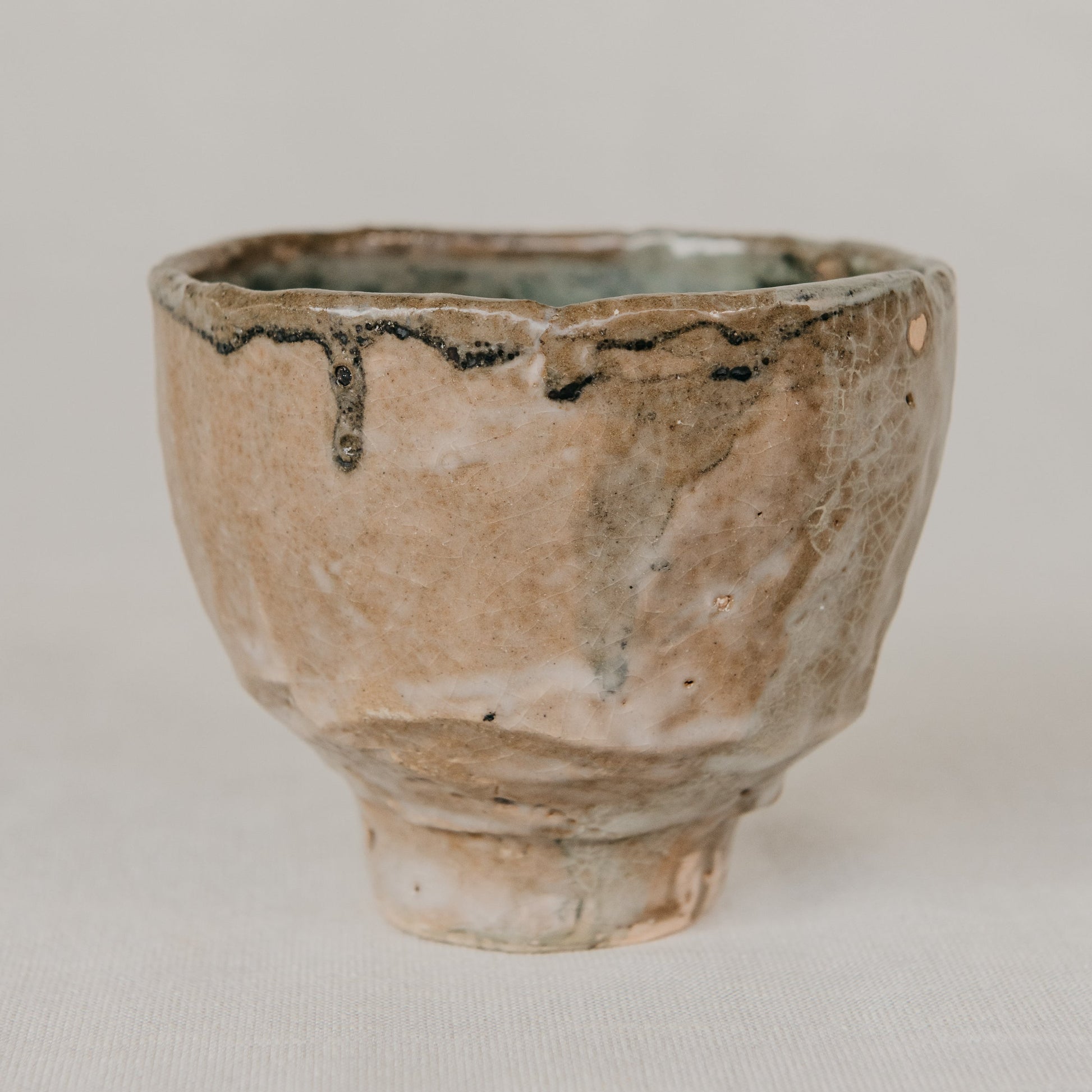 Ceramic cup with a textured surface on a neutral background
