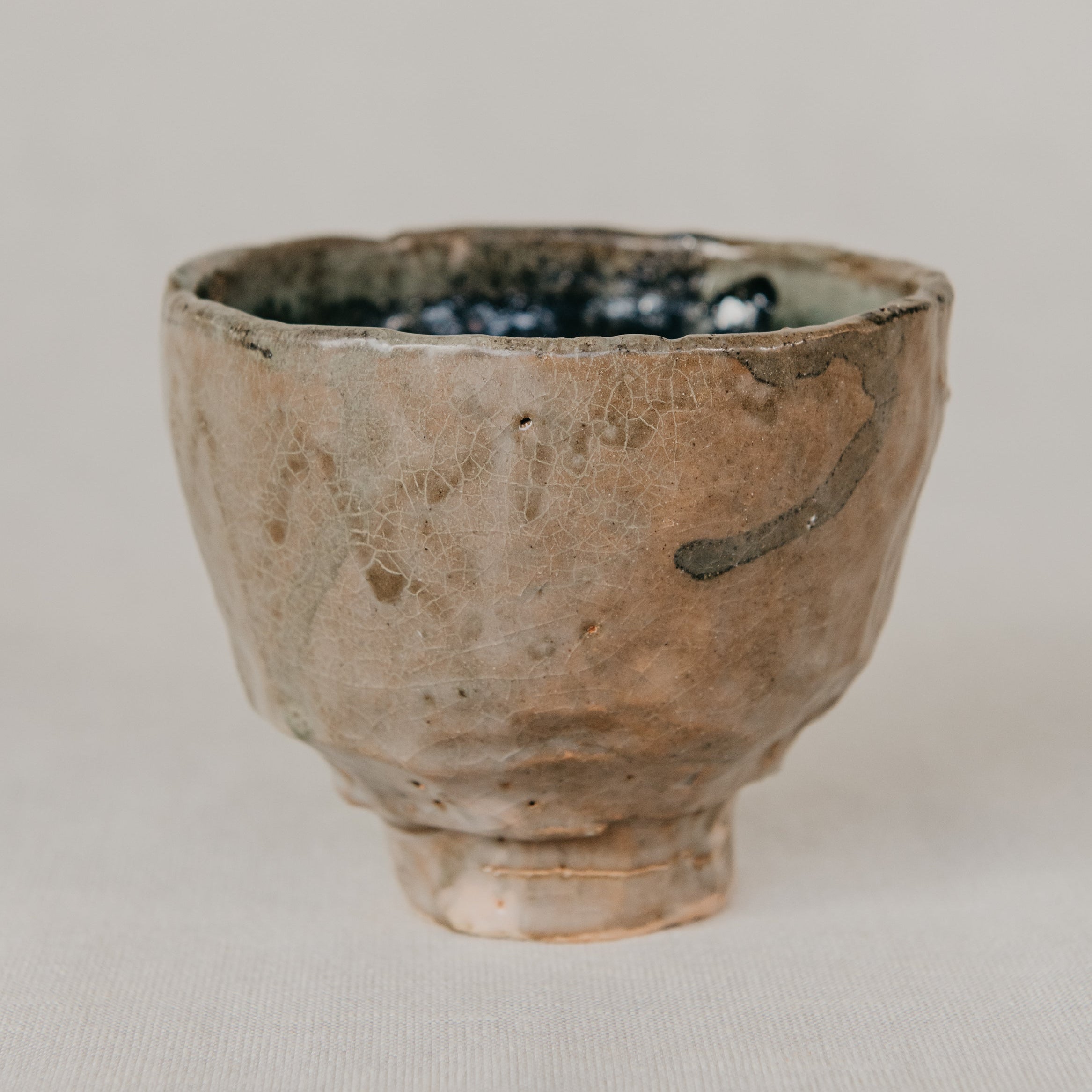 Ceramic cup with a textured surface on a neutral background