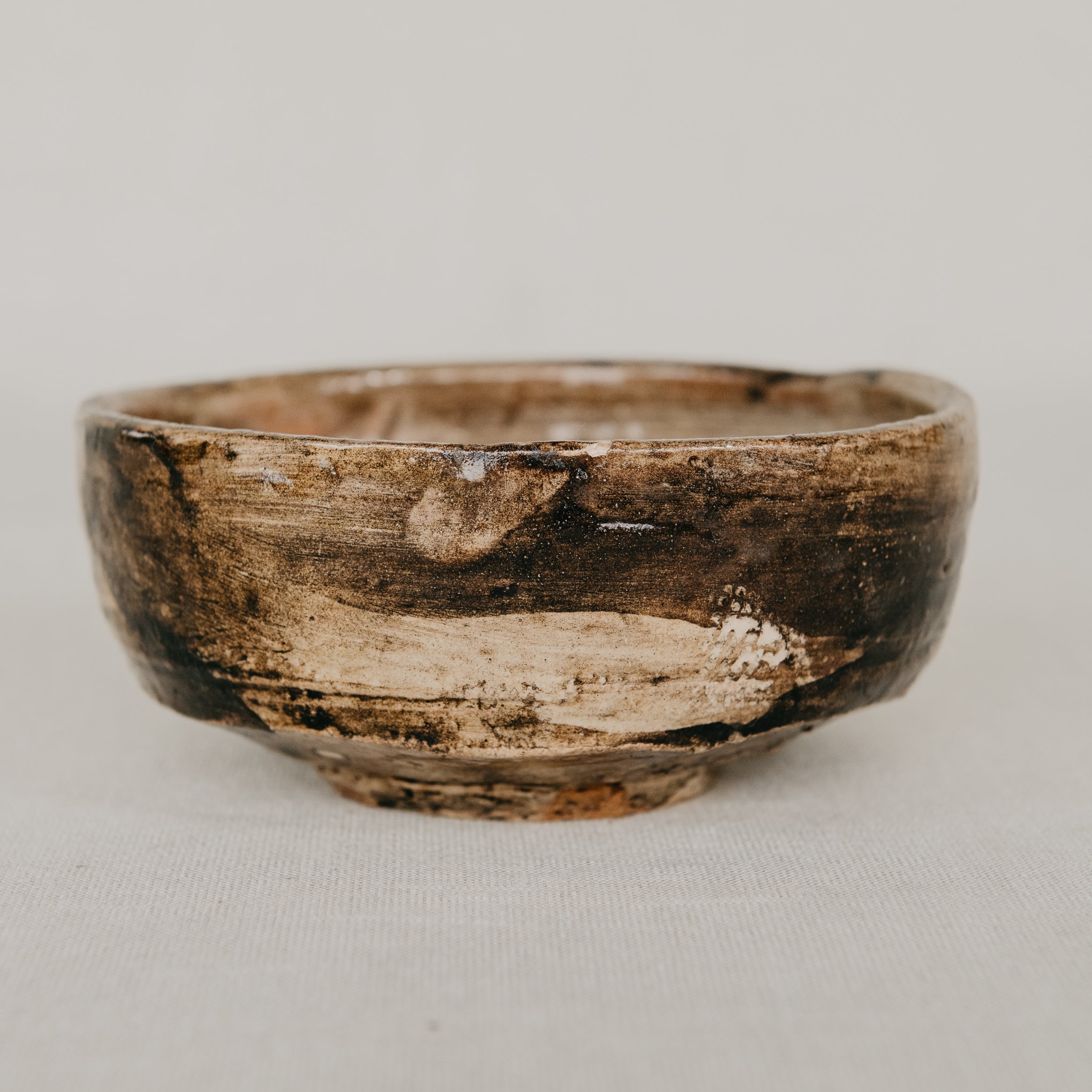 Small wooden bowl with a natural finish on a light gray background