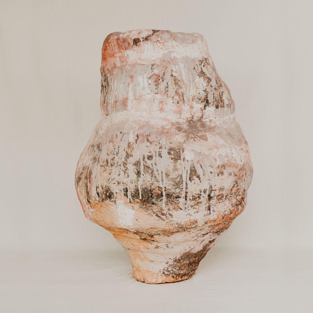 Vintage terracotta vase with a textured surface on a plain background