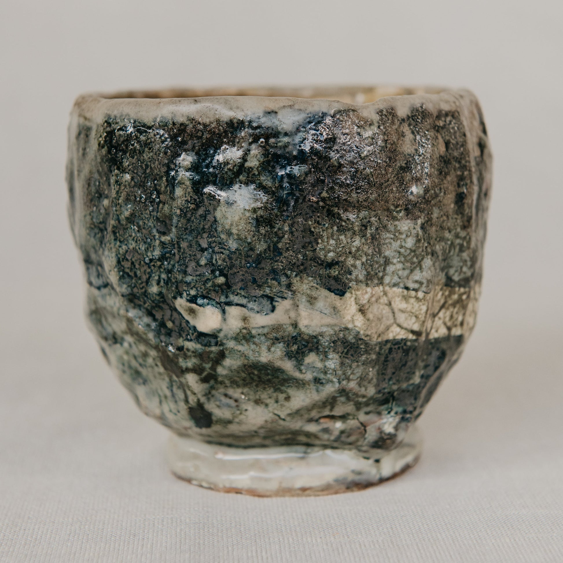 Ceramic cup with textured surface on a plain background