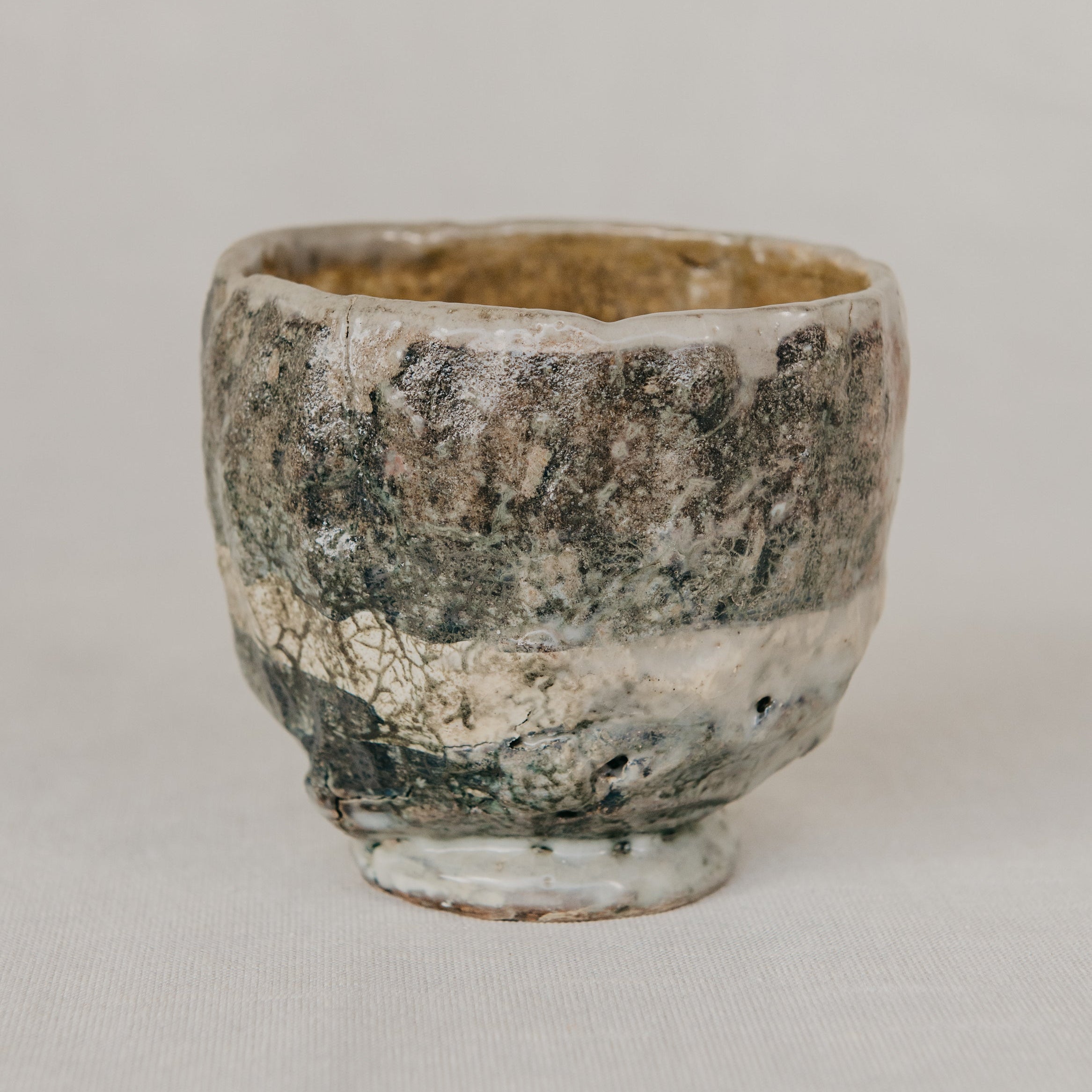 Ceramic cup with textured surface on a plain background