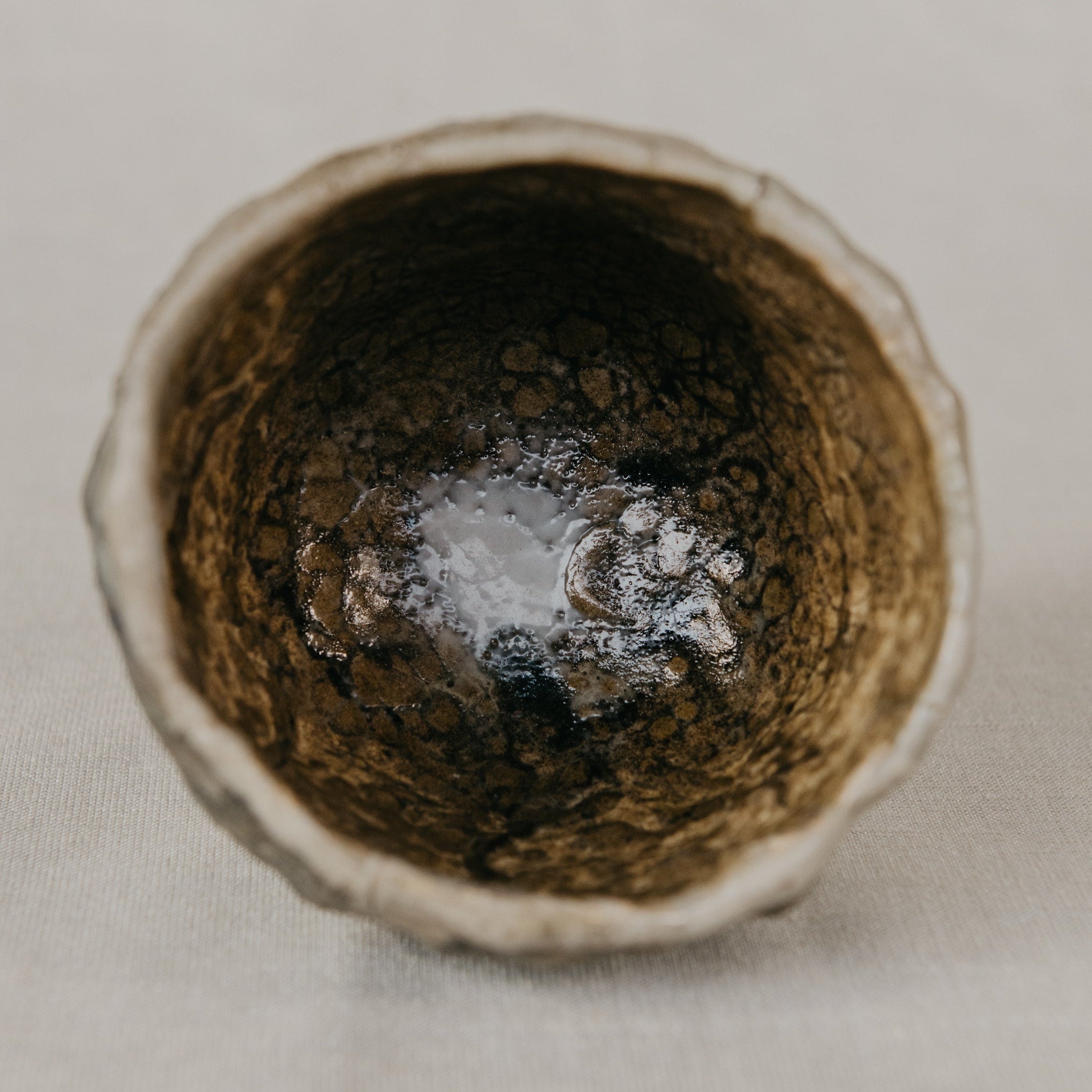 Close-up of a ceramic bowl with a textured interior on a neutral background