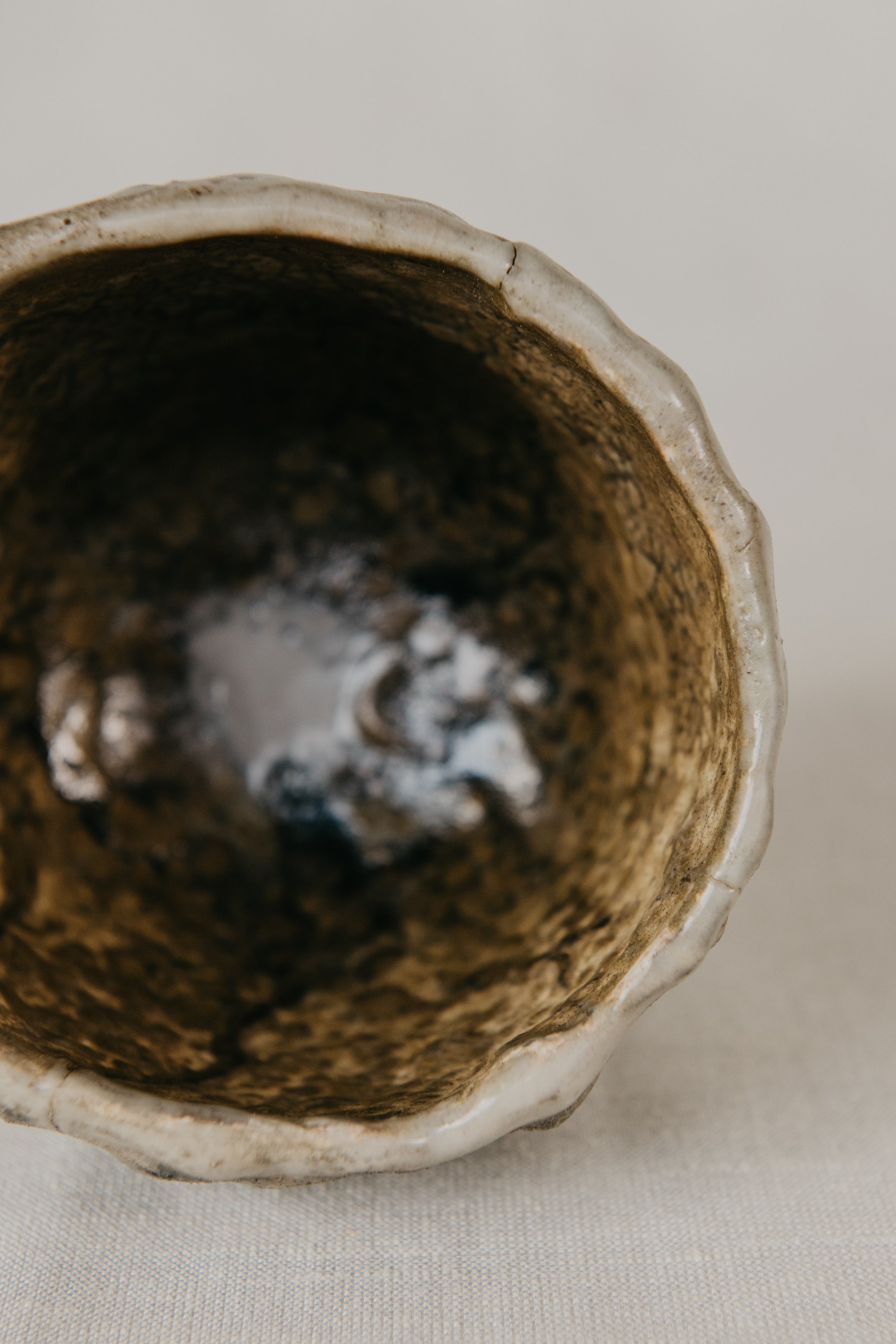 Close-up of a ceramic bowl with a textured interior on a neutral background