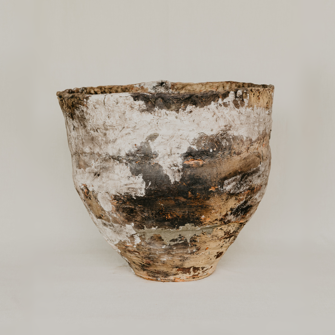 Vintage ceramic pot with a textured surface on a plain background