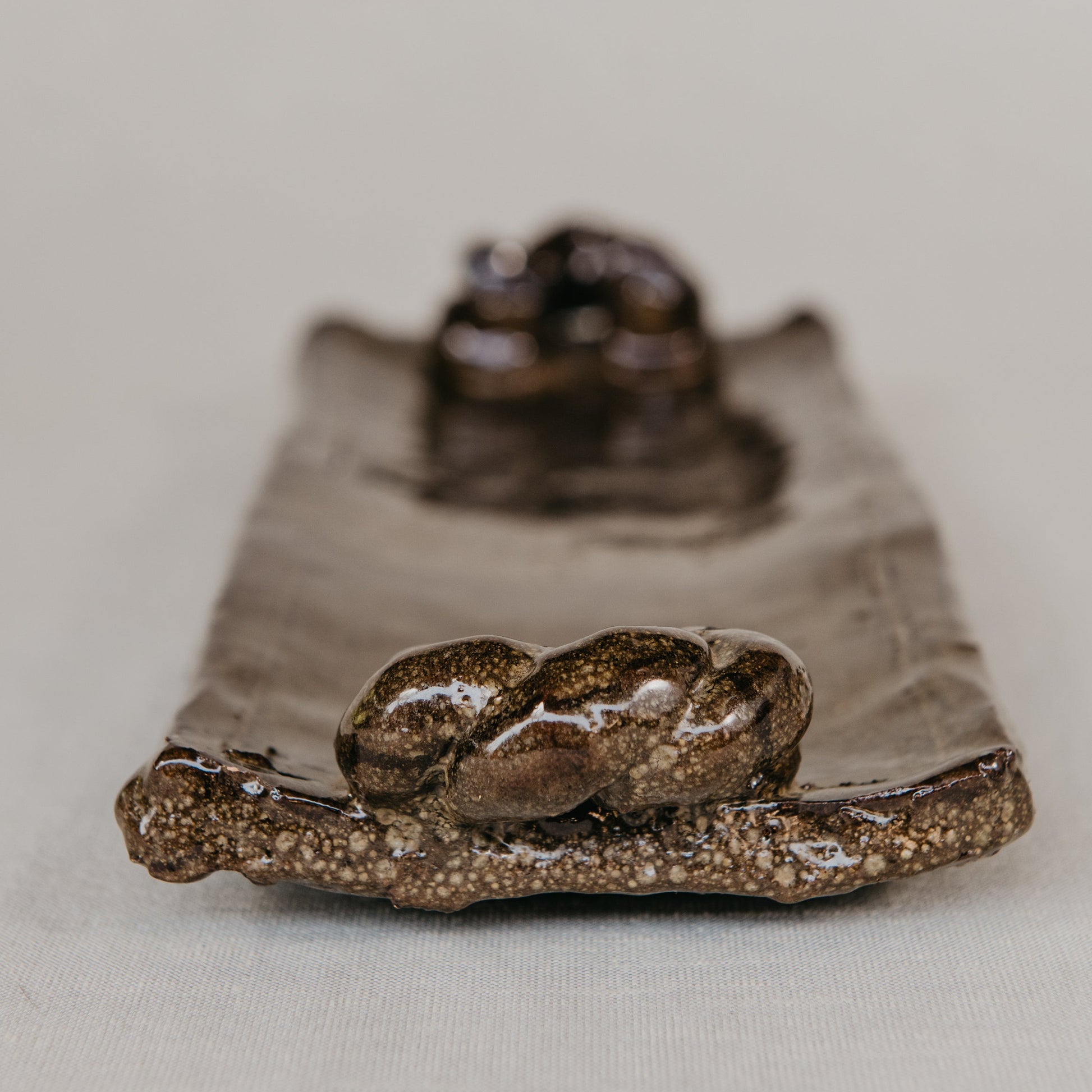 Green ceramic pot with textured surface on a wooden surface