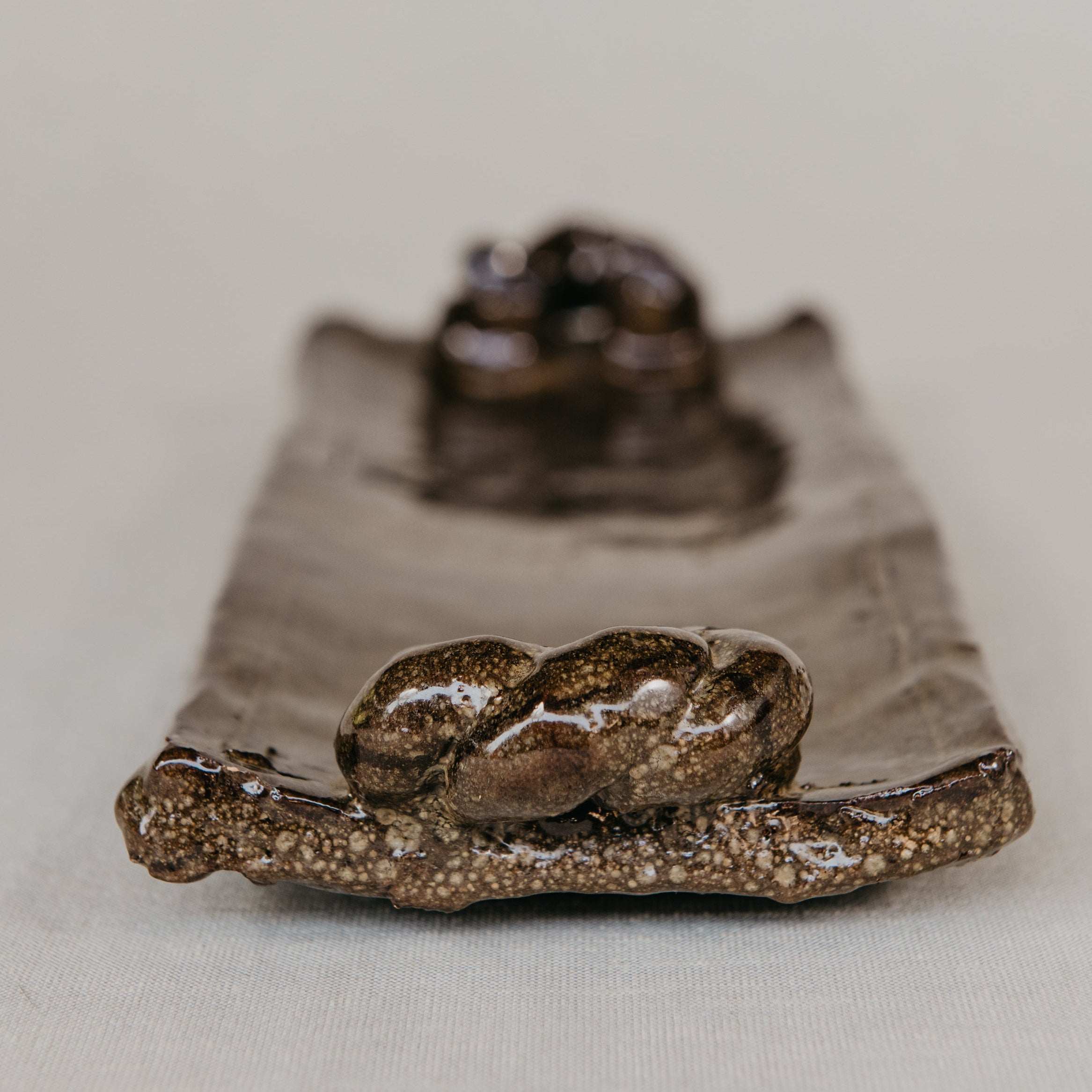 Green ceramic pot with textured surface on a wooden surface