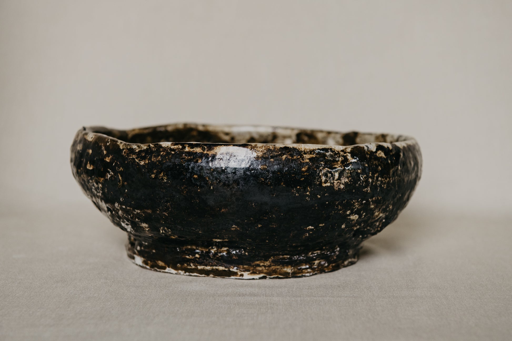 Brown ceramic bowl with a textured surface on a neutral background