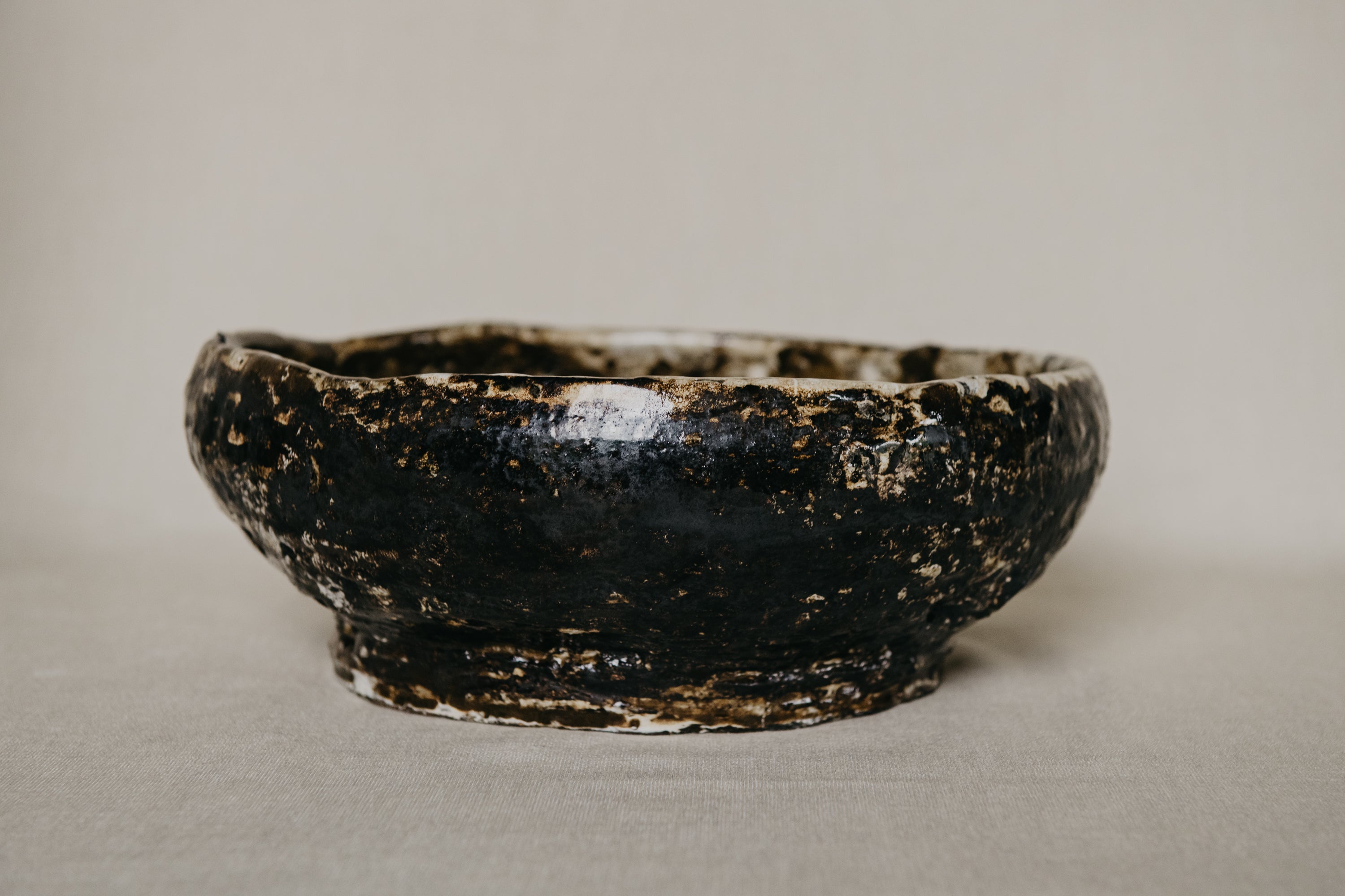 Brown ceramic bowl with a textured surface on a neutral background