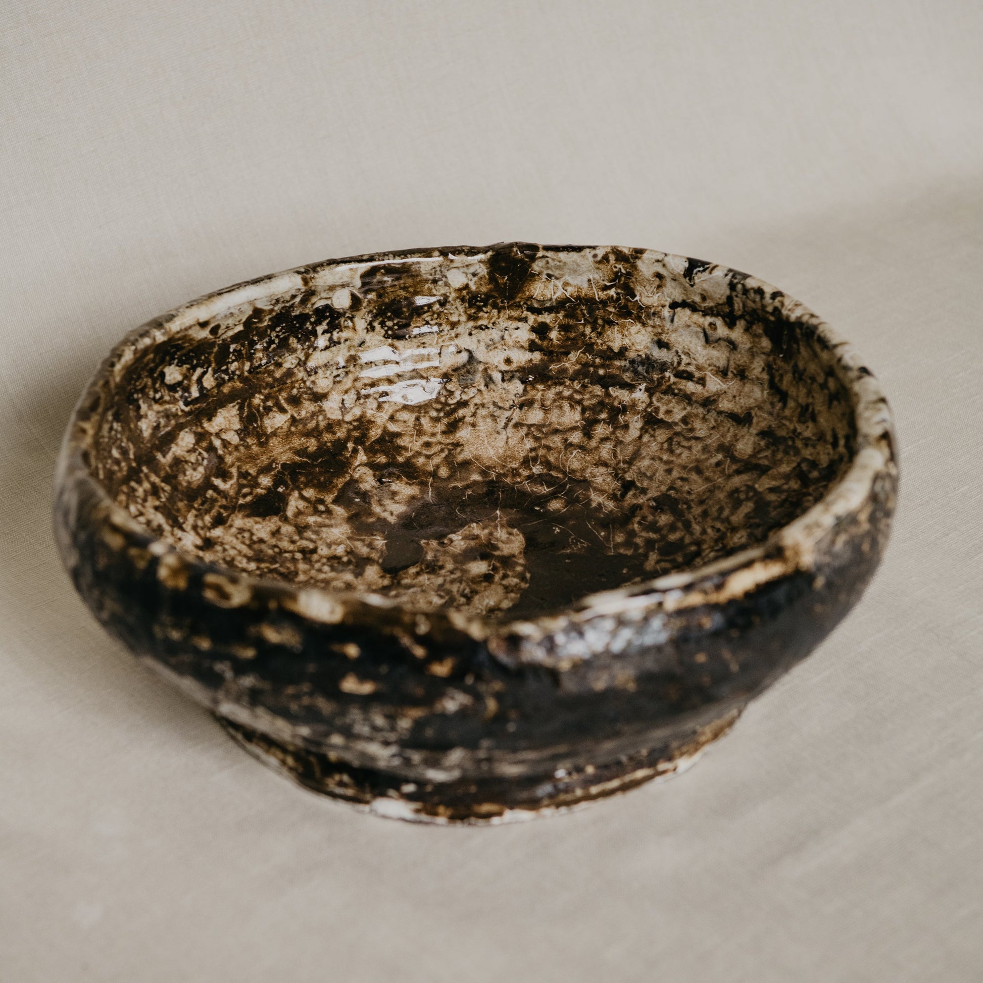 Vintage ceramic bowl with a textured surface on a beige background