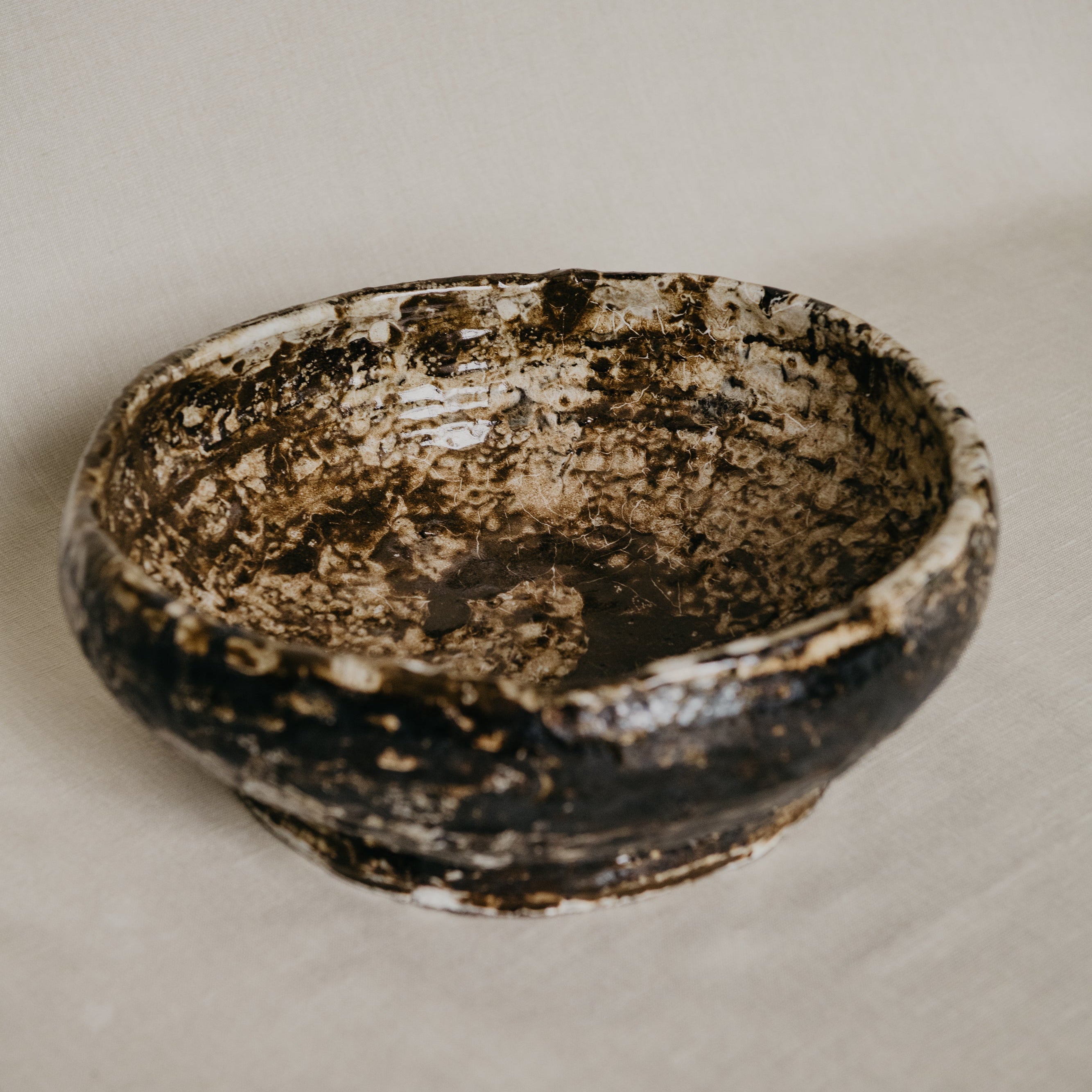 Vintage ceramic bowl with a textured surface on a beige background