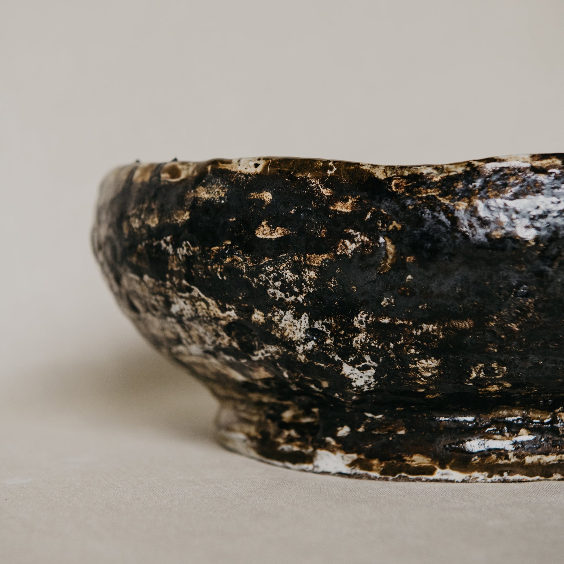 Brown ceramic bowl with textured surface on a beige background