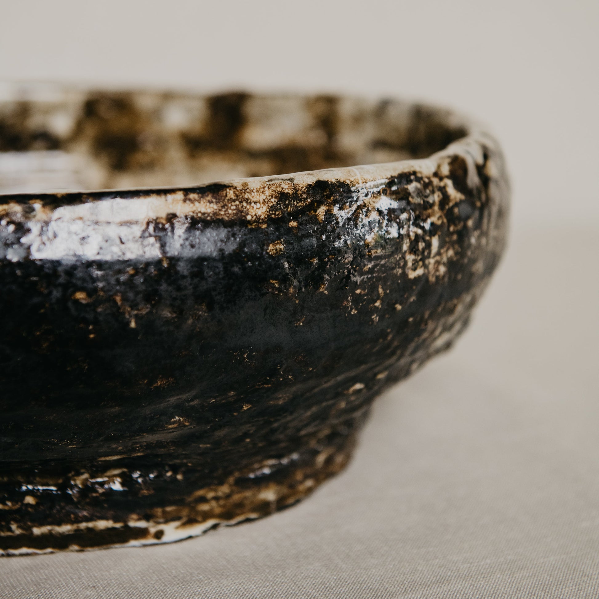 Close-up of a brown ceramic bowl on a textured surface