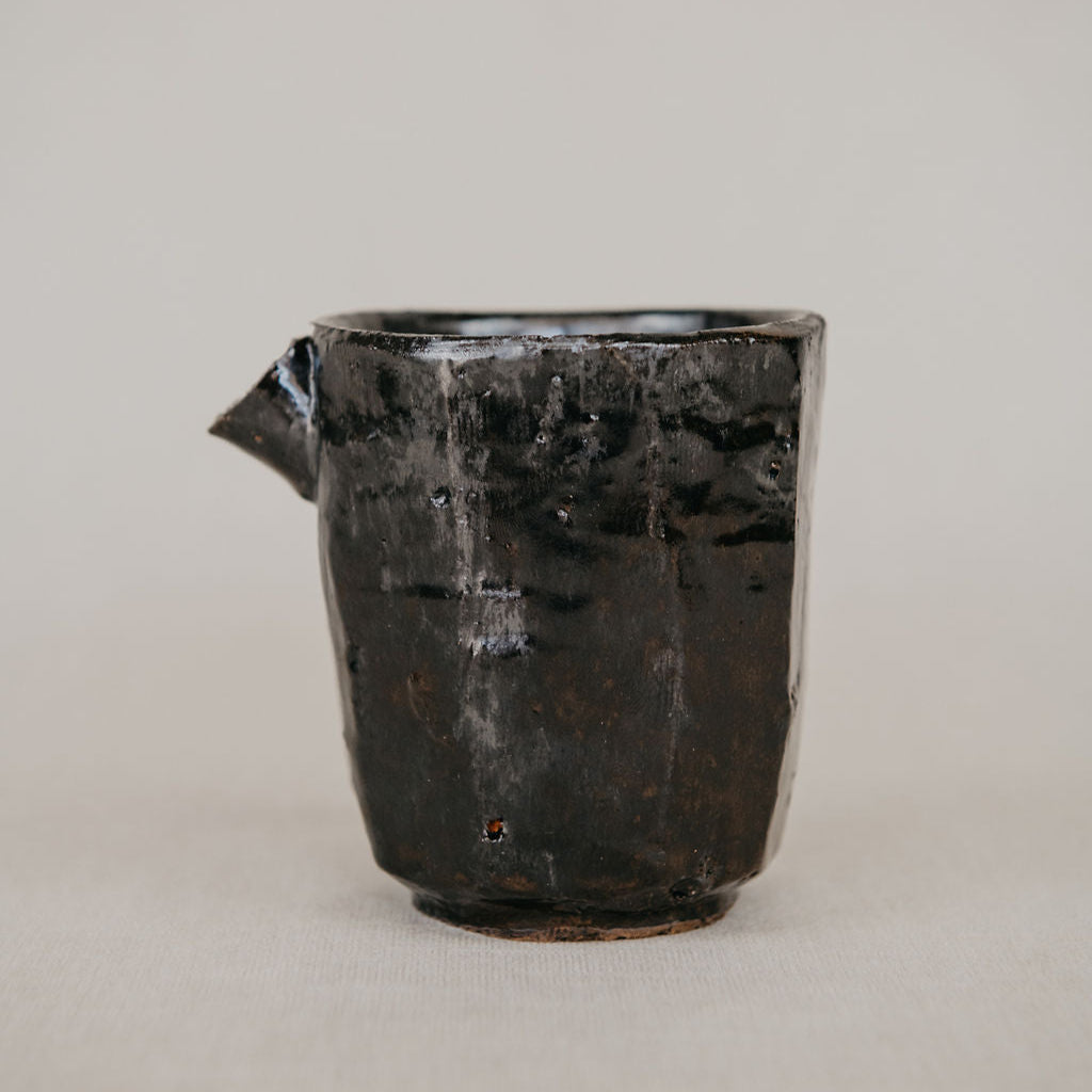 Black ceramic vase on a light gray background