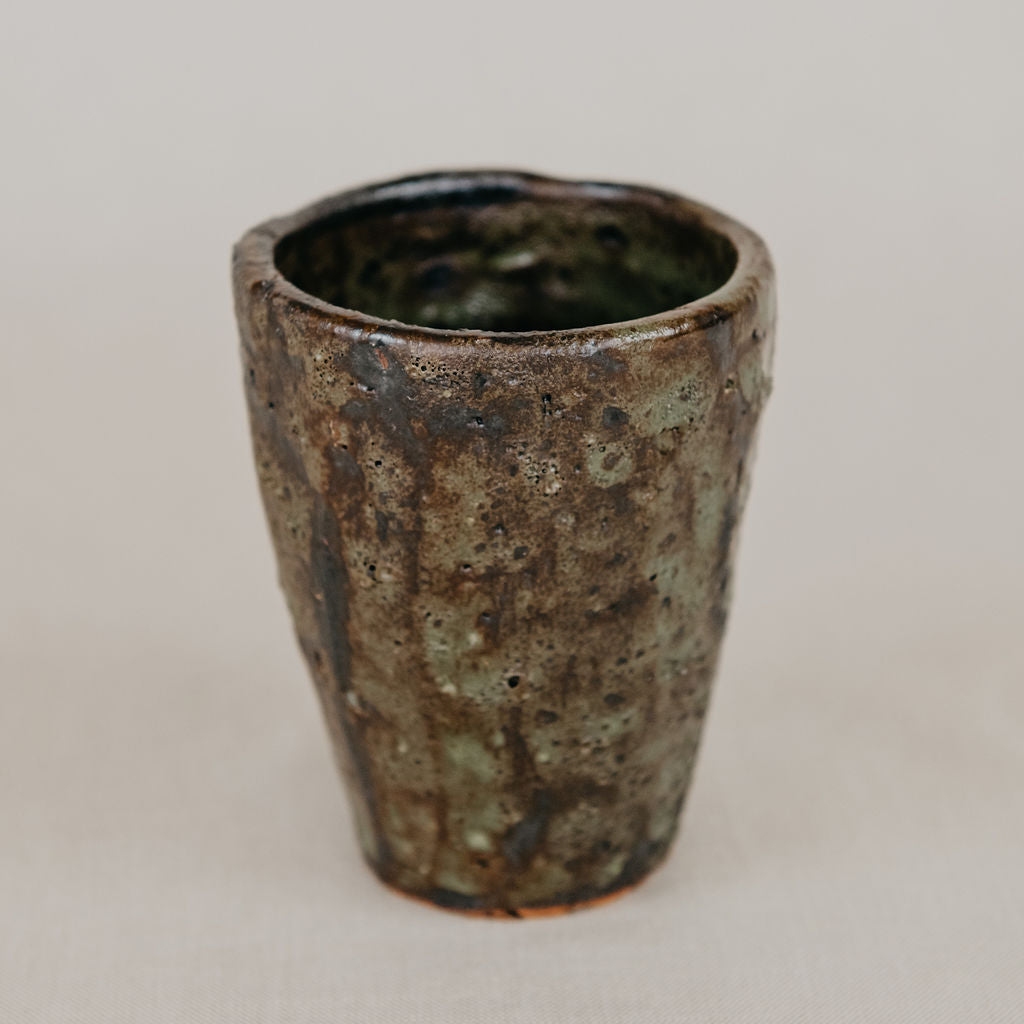 Ceramic cup with textured surface on a plain background