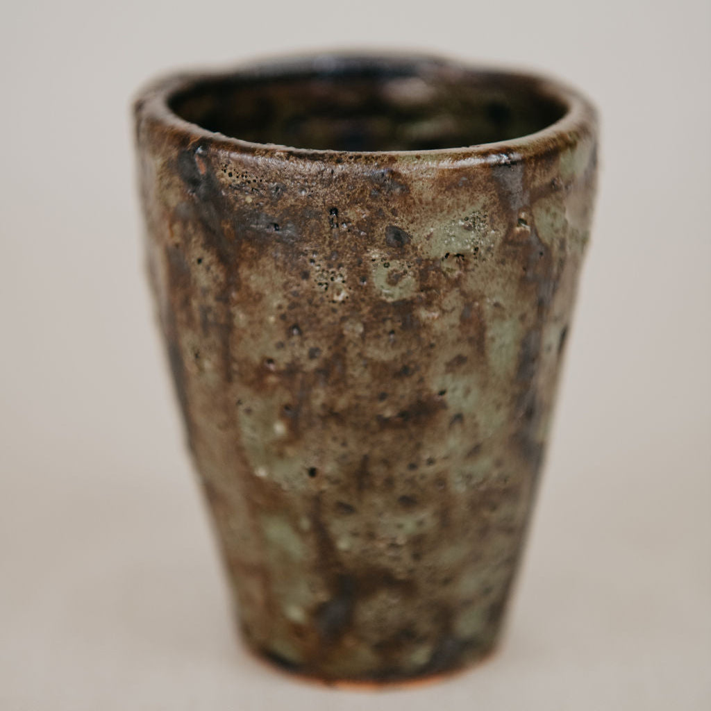Ceramic cup with a textured surface on a plain background