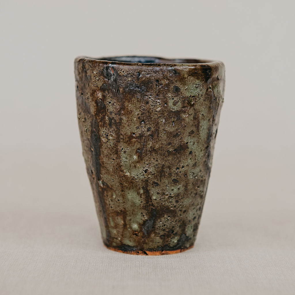 Ceramic cup with a textured surface on a plain background