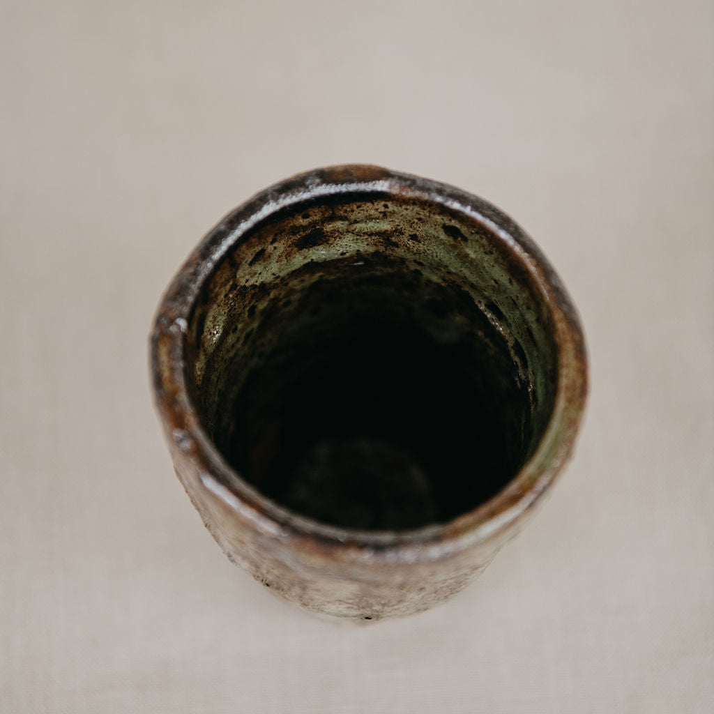 Ceramic vase with textured surface on a beige background