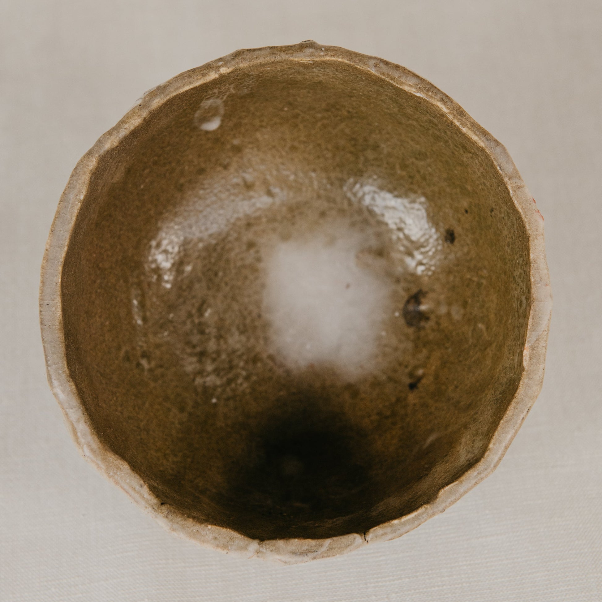 Close-up of a ceramic bowl with a textured interior on a beige background