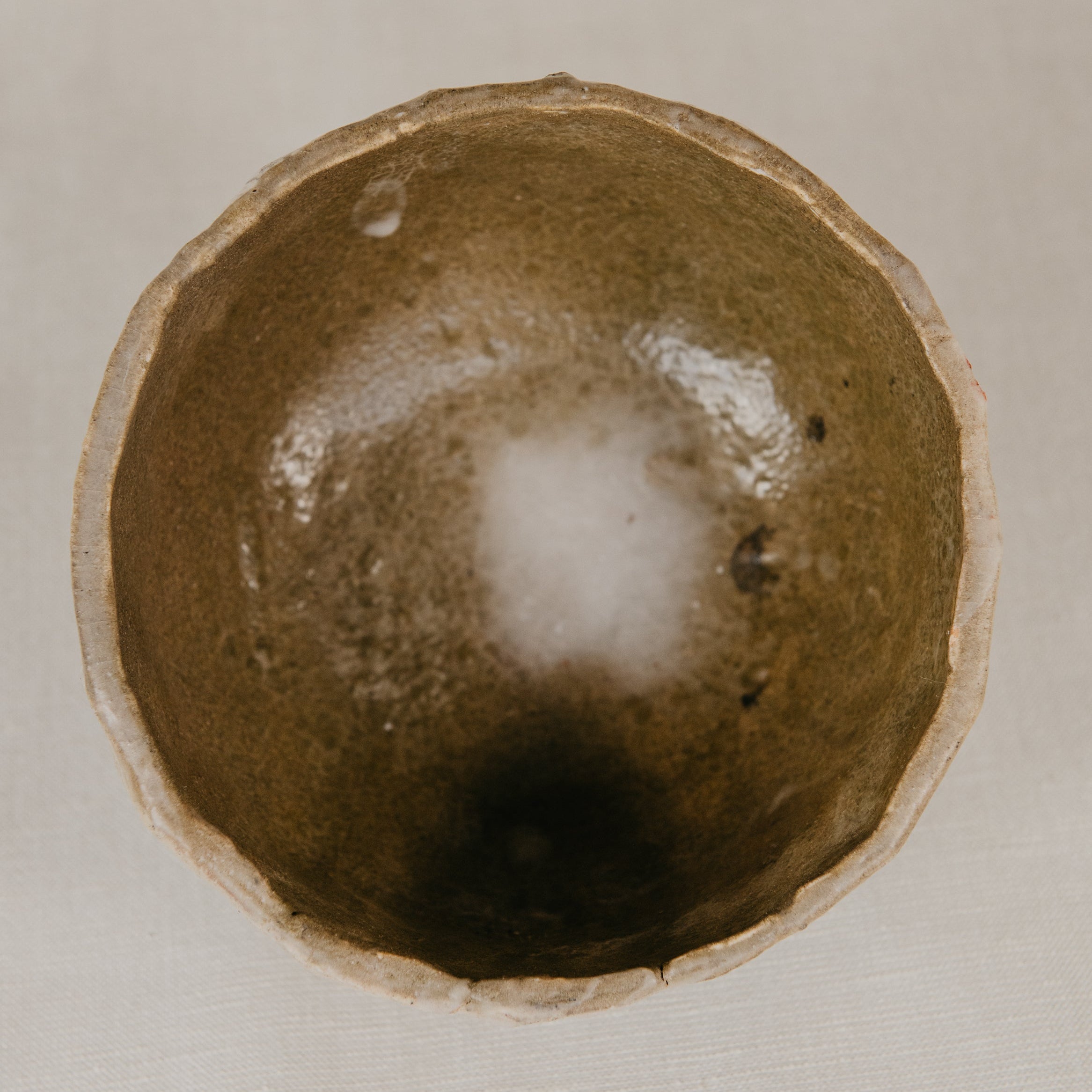 Close-up of a ceramic bowl with a textured interior on a beige background
